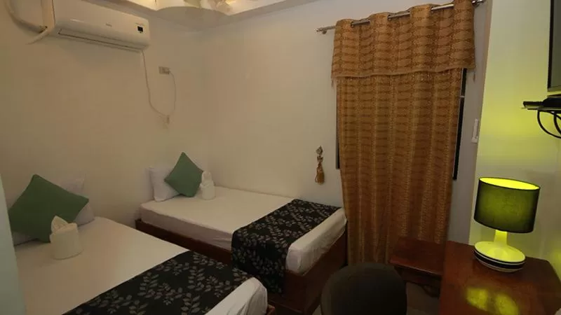 Bed in El Nido Royal Palm Inn