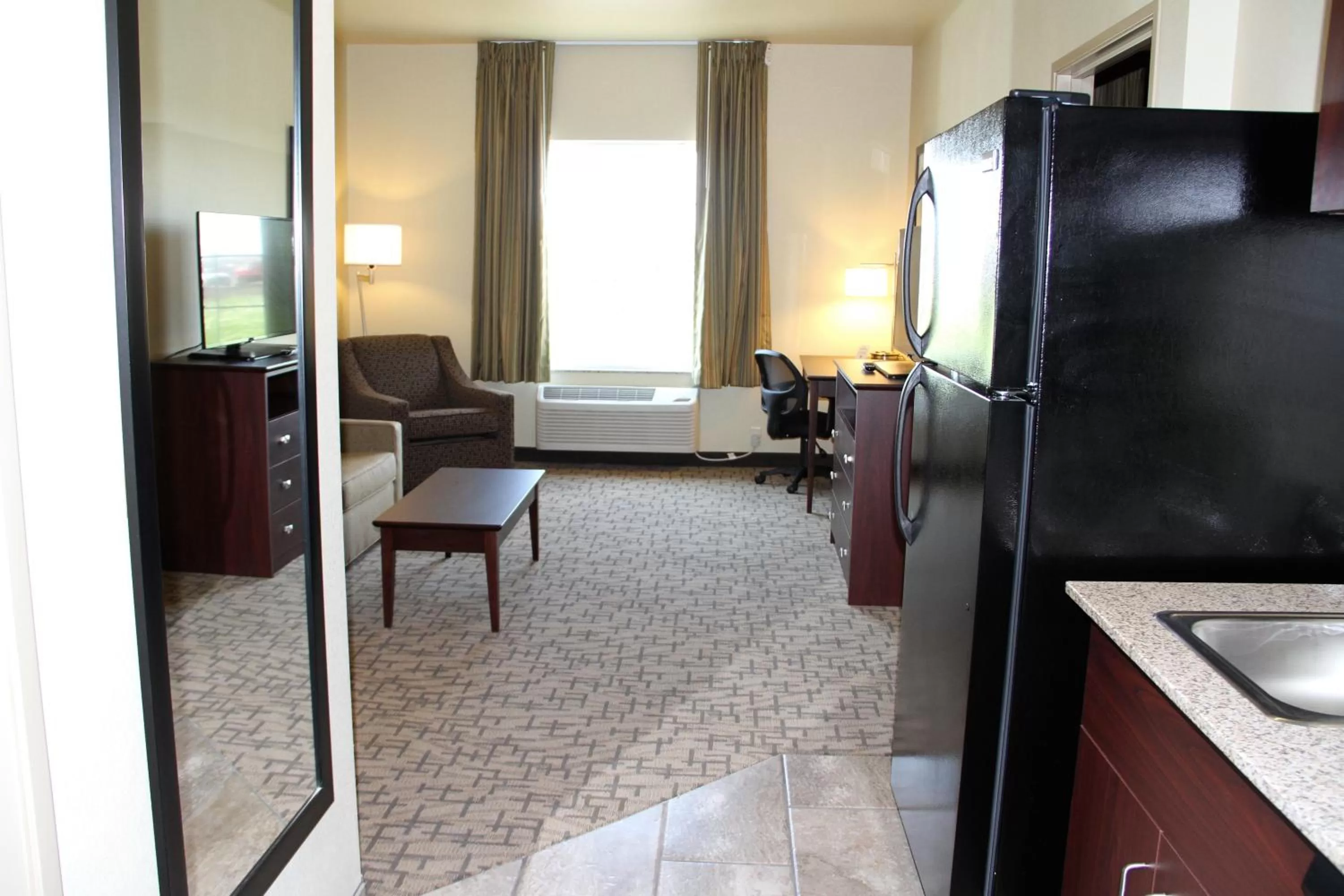 Living room, Bed in Cobblestone Hotel & Suites - Devils Lake