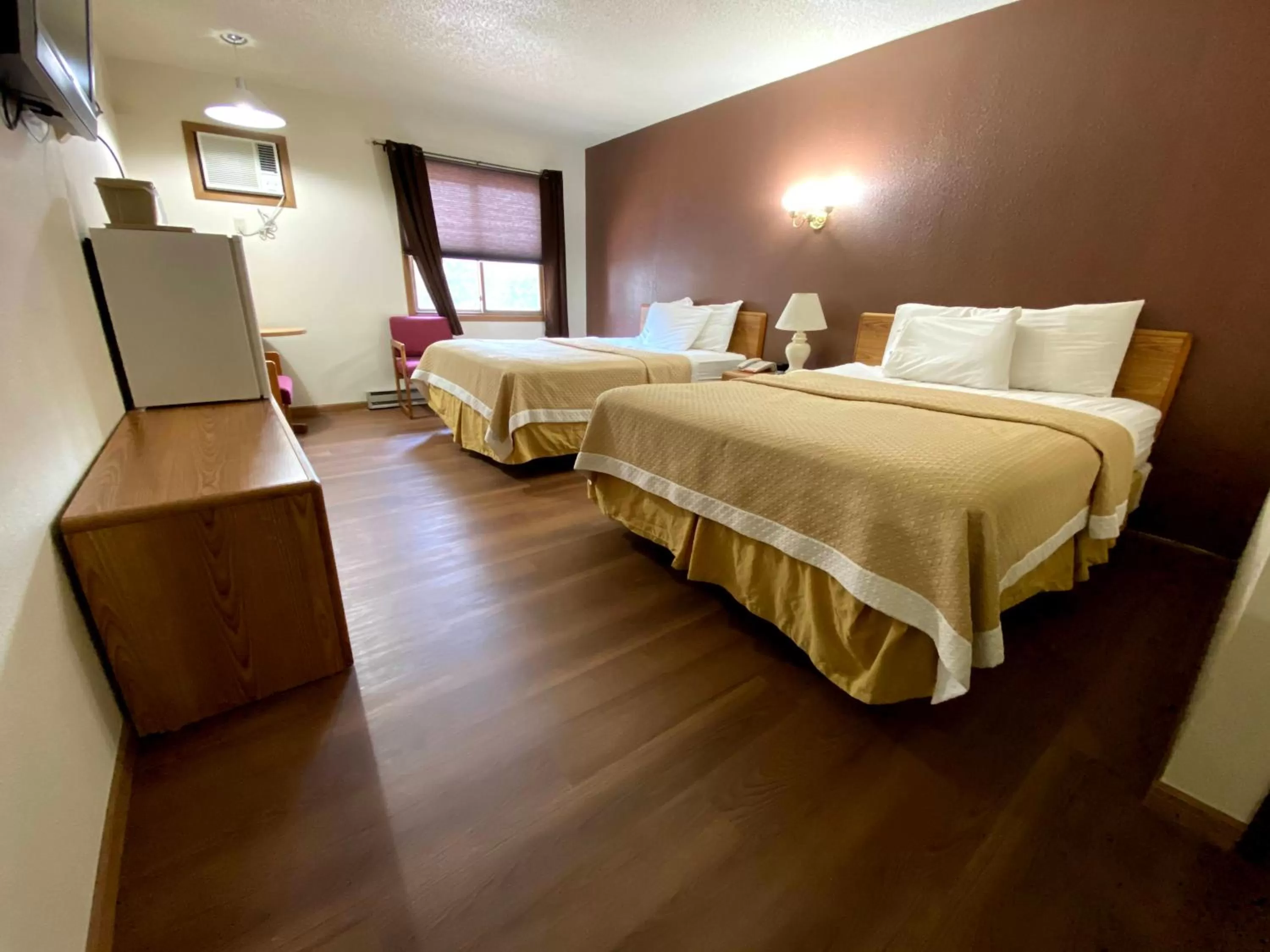 Bed in Woodland Inn & Suites