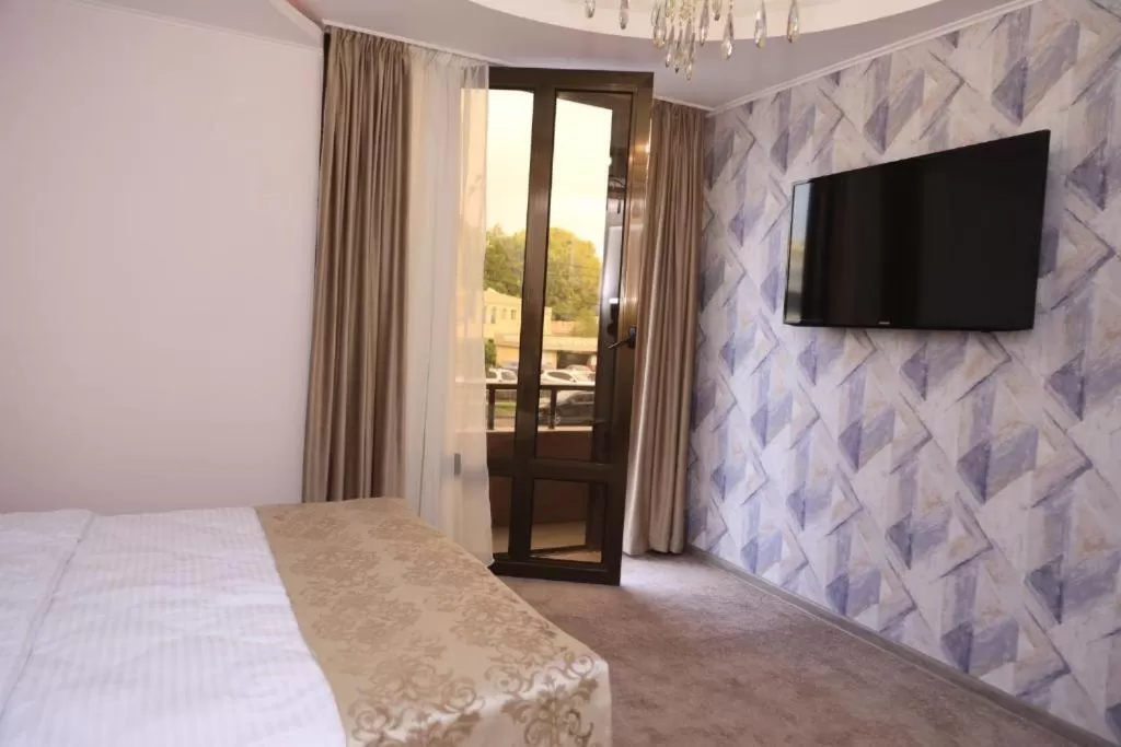 Bed, TV/Entertainment Center in DeLin Hotel And Tours