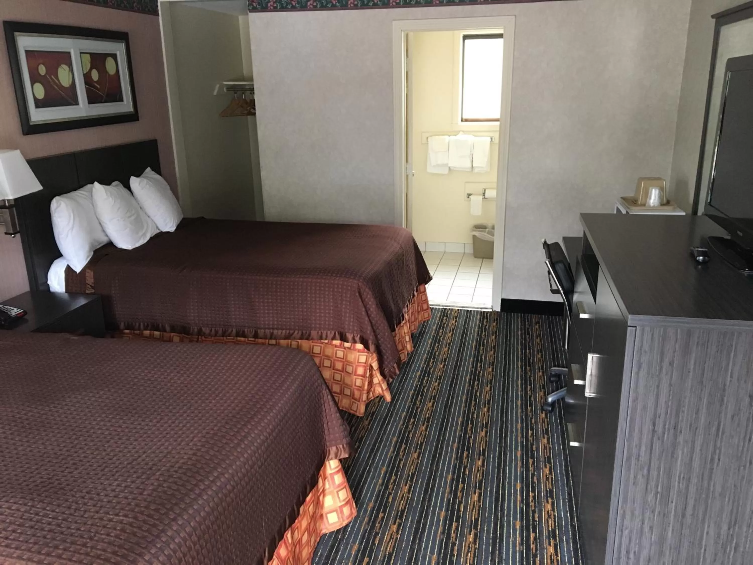 Bed in Whitney Inn & Suites