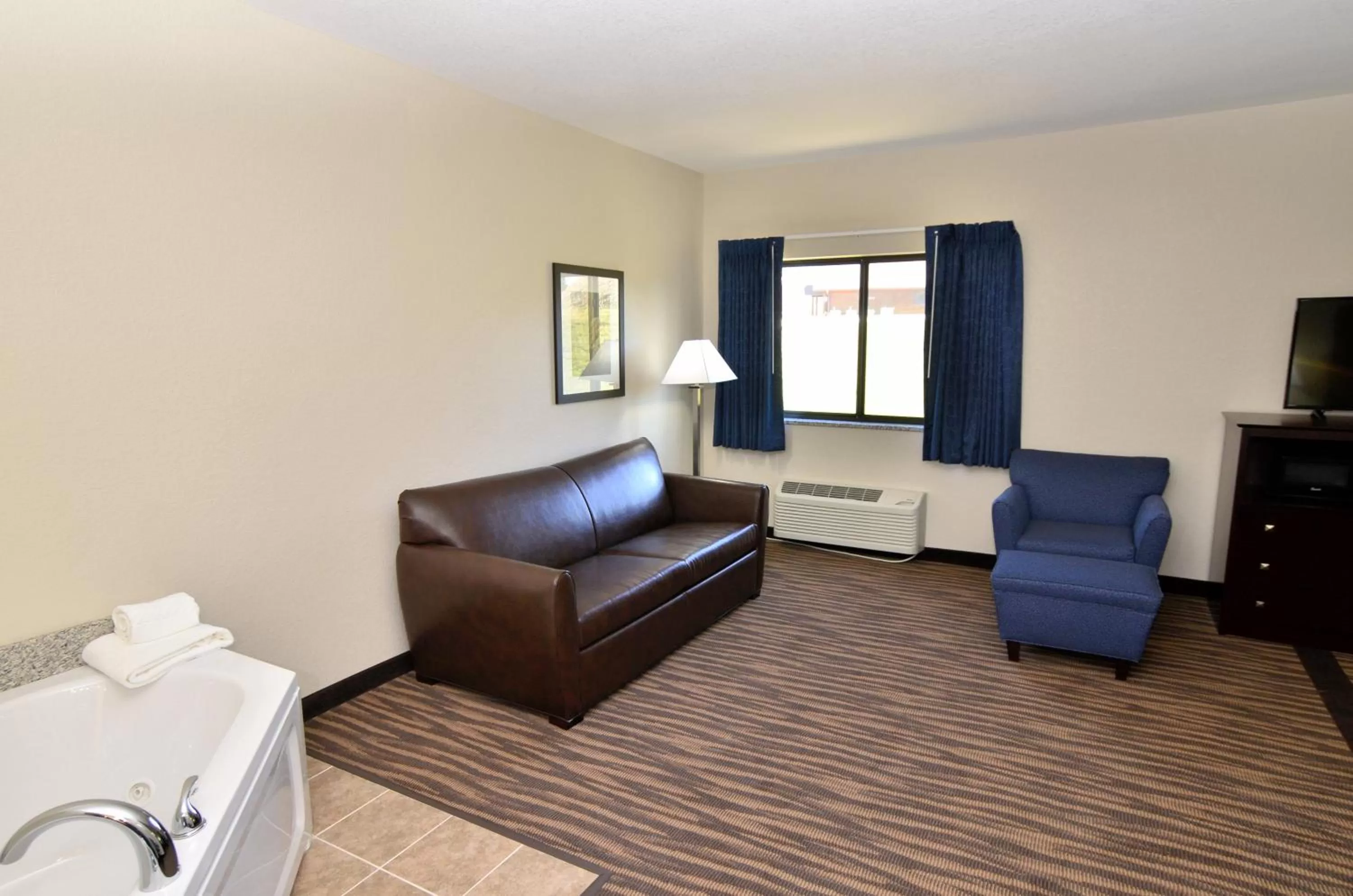 Seating area, Bed in Cobblestone Inn & Suites - Manning