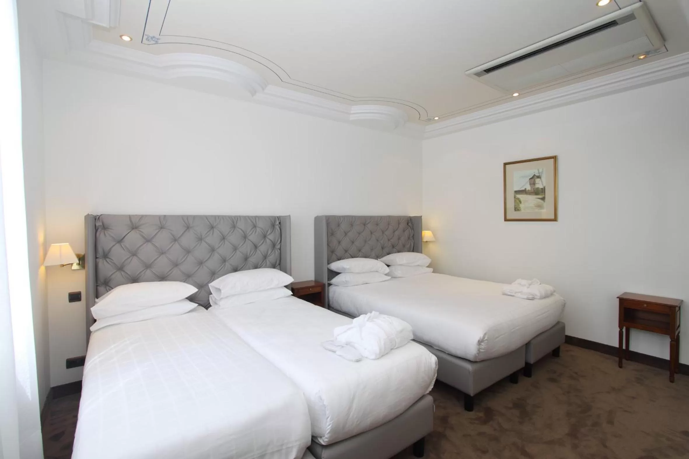 Bed in GOLDEN TULIP CANNES HOTEL de PARIS