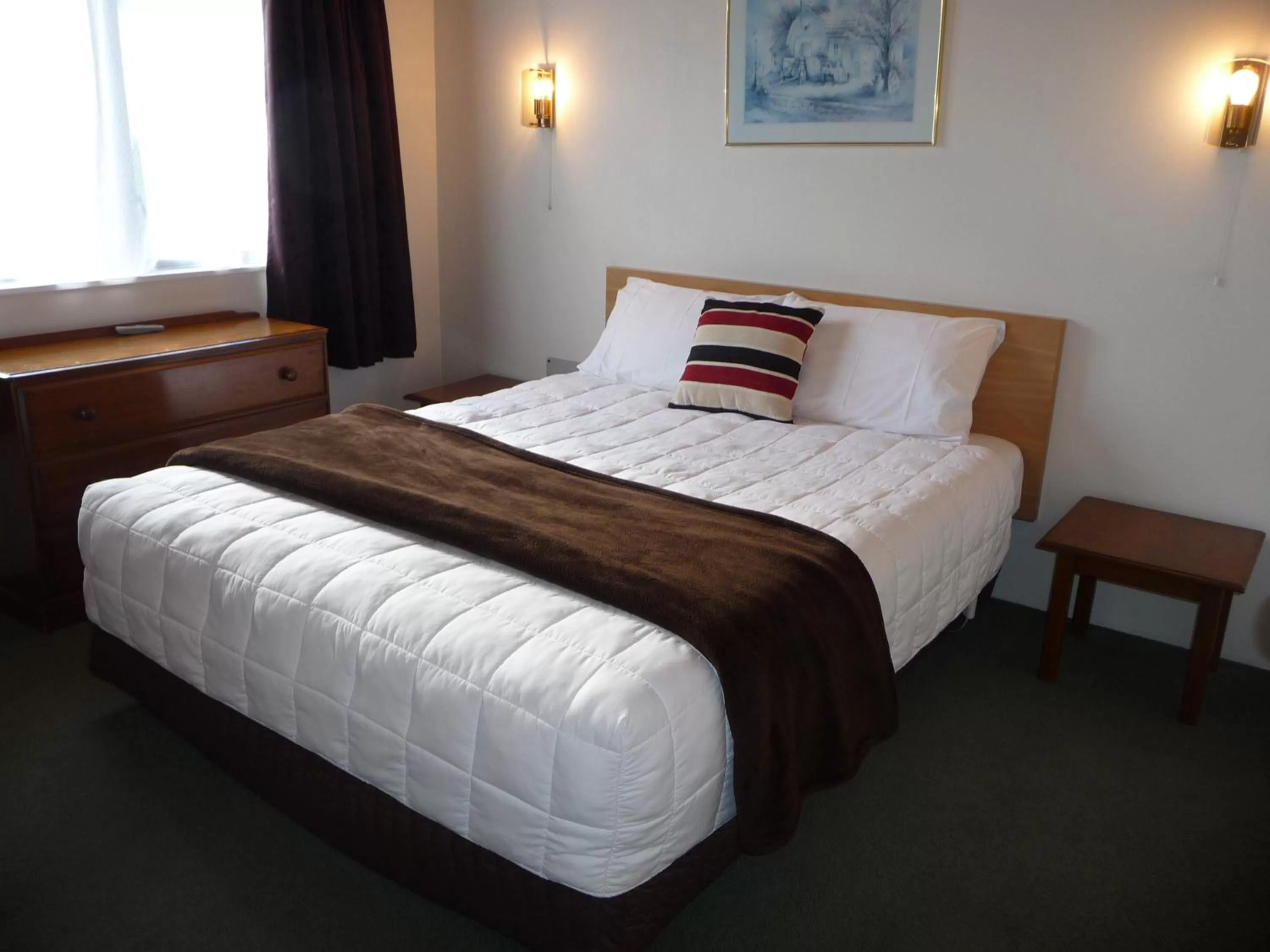 Bed in Coachman's Lodge Motel