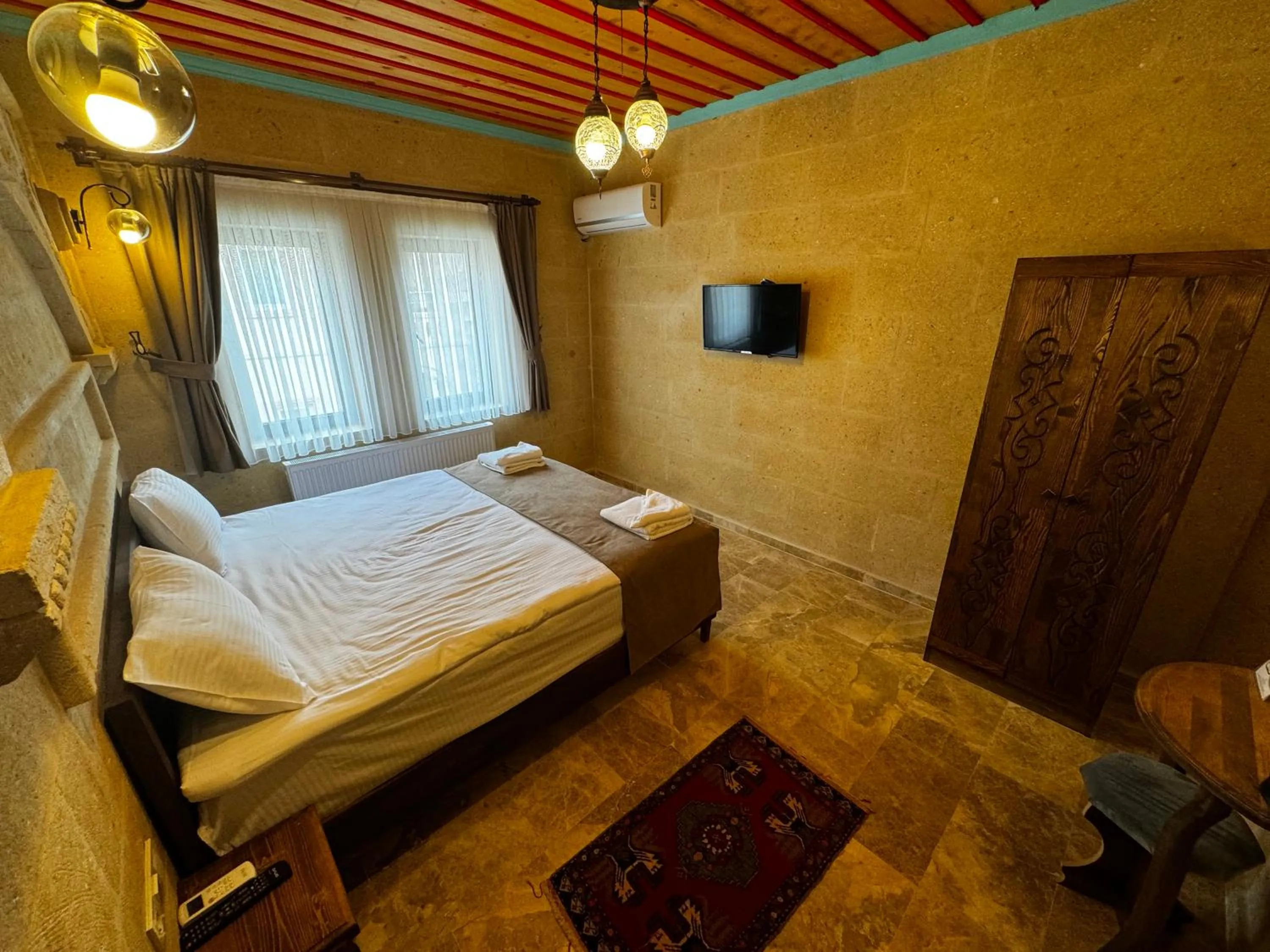 Communal lounge/ TV room, Bed in Rustic Caves