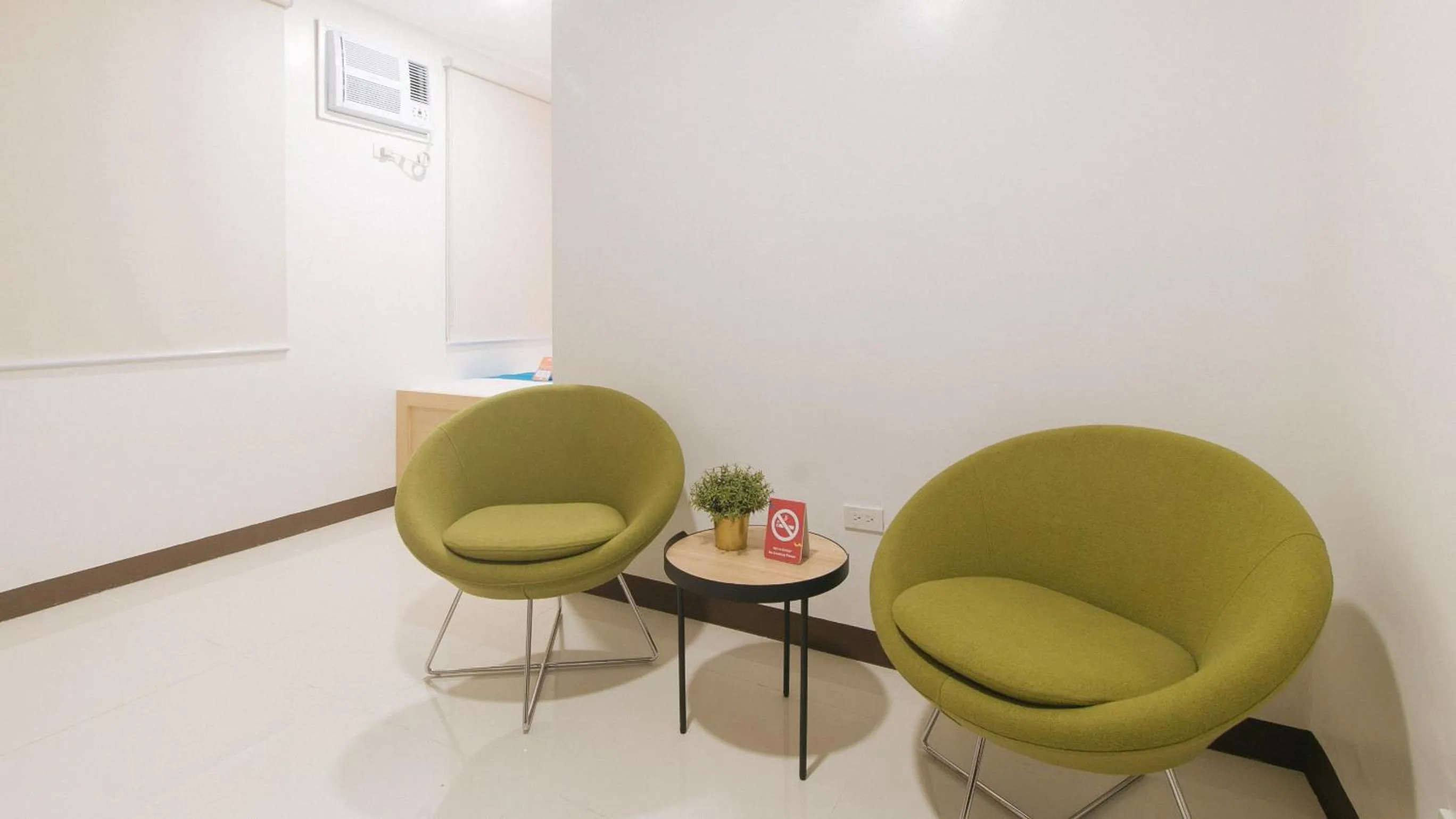 Seating area in Sans Hotel at One JD Place Makati by RedDoorz