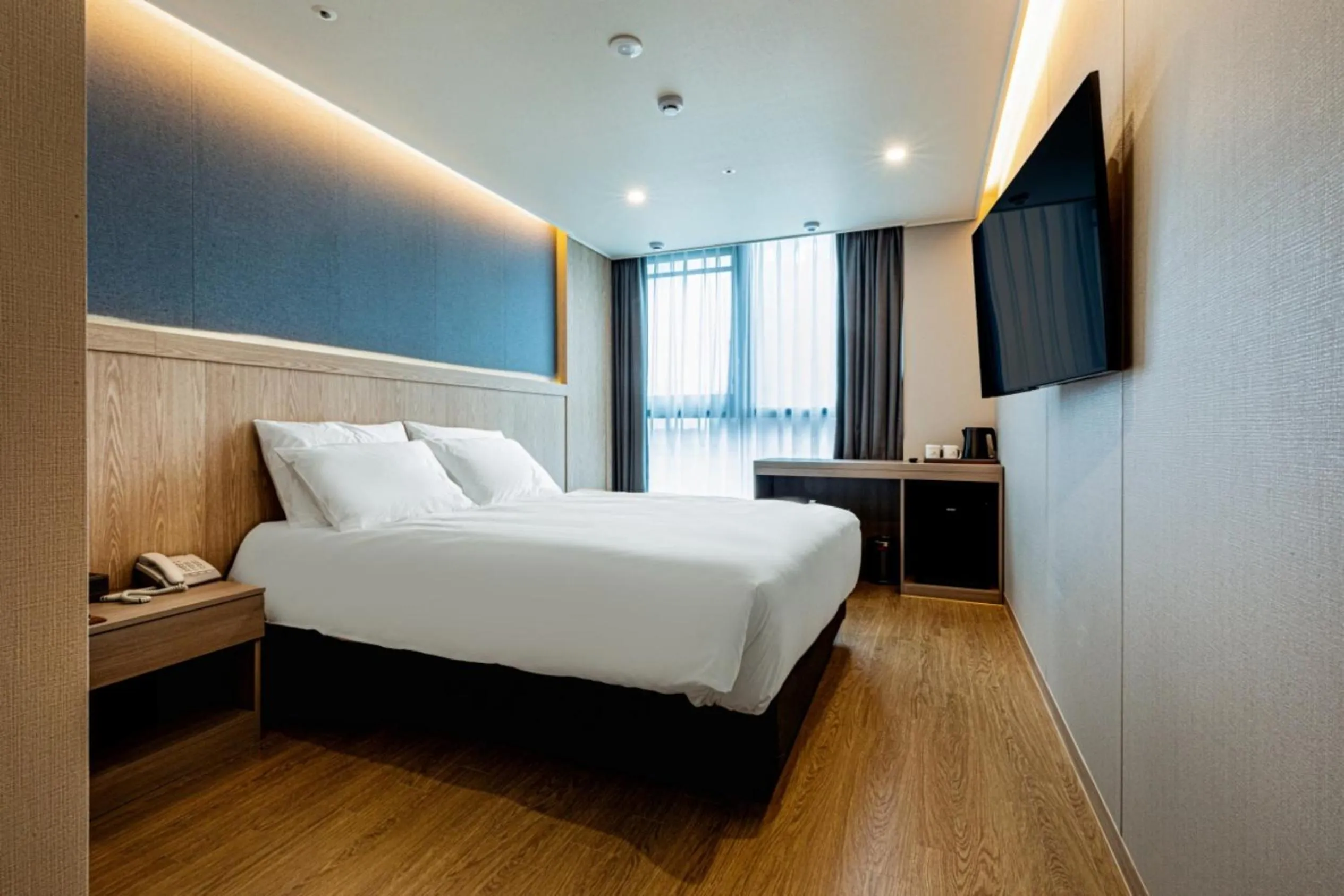 Communal lounge/ TV room, Bed in Jeju Bolton Hotel