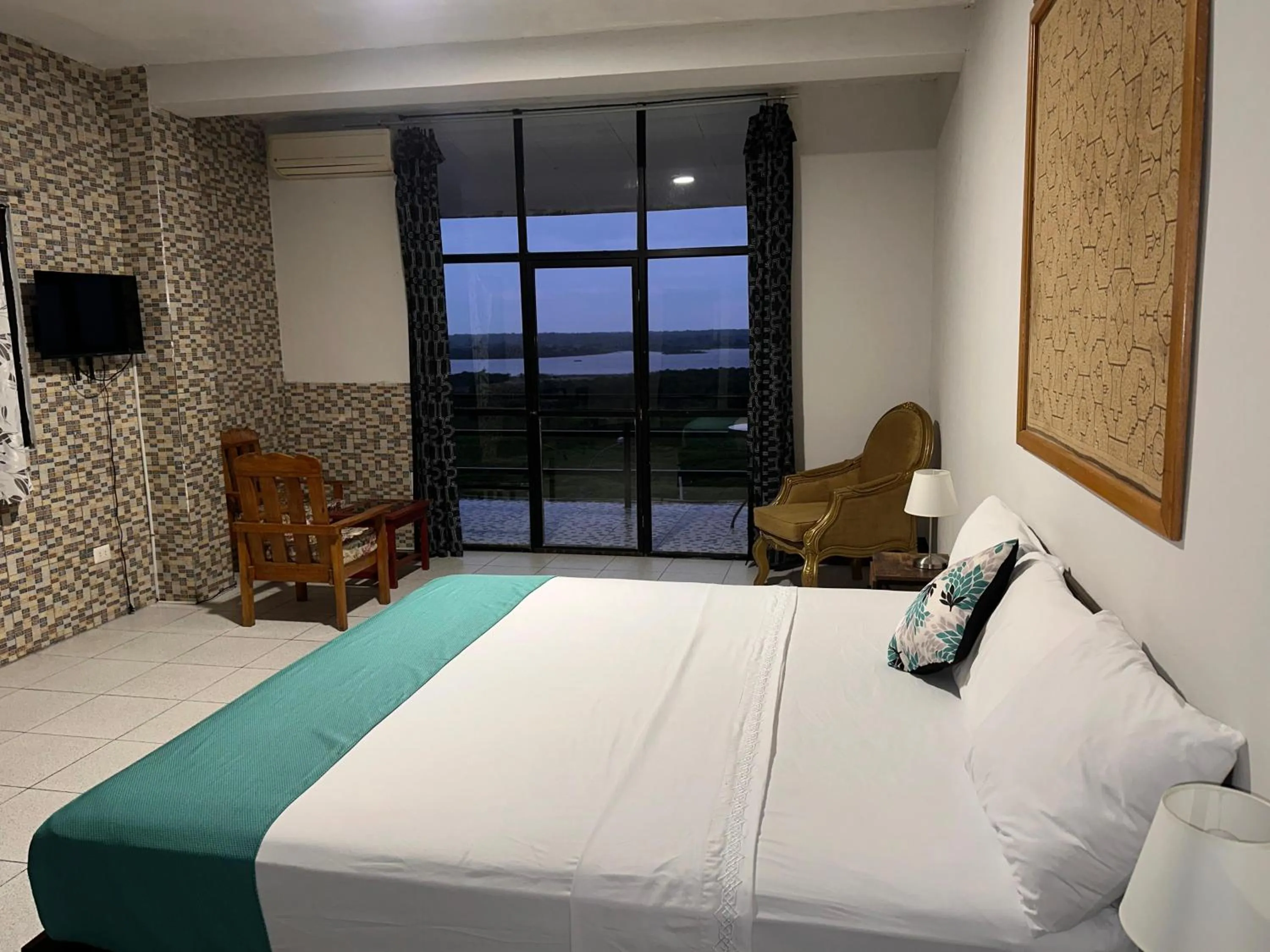 Communal lounge/ TV room, Bed in La Posada del Cauchero Hotel & Suites