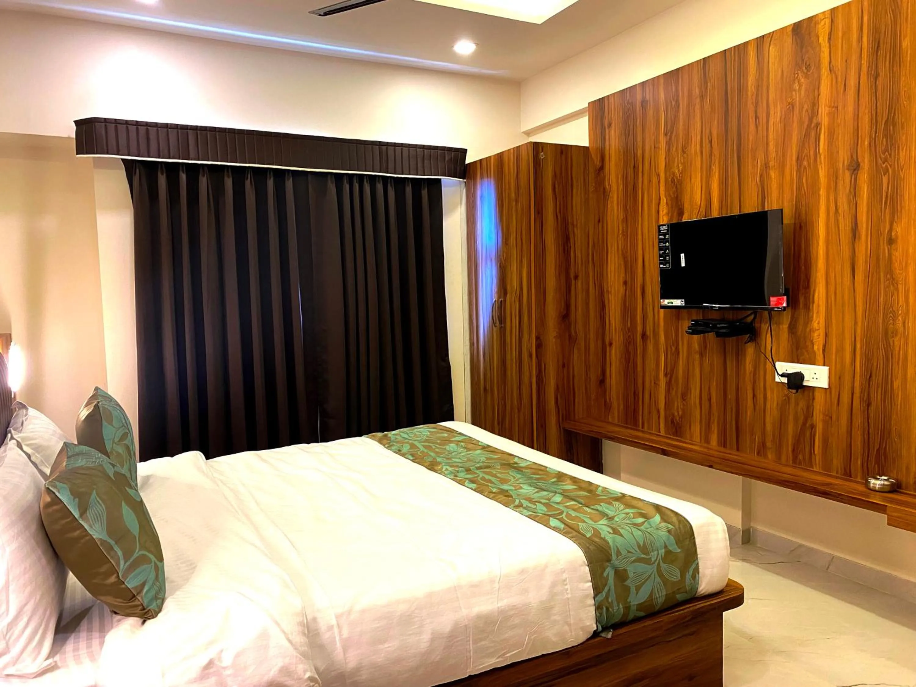 Bed in The Grand Sarovar Inn And Suites
