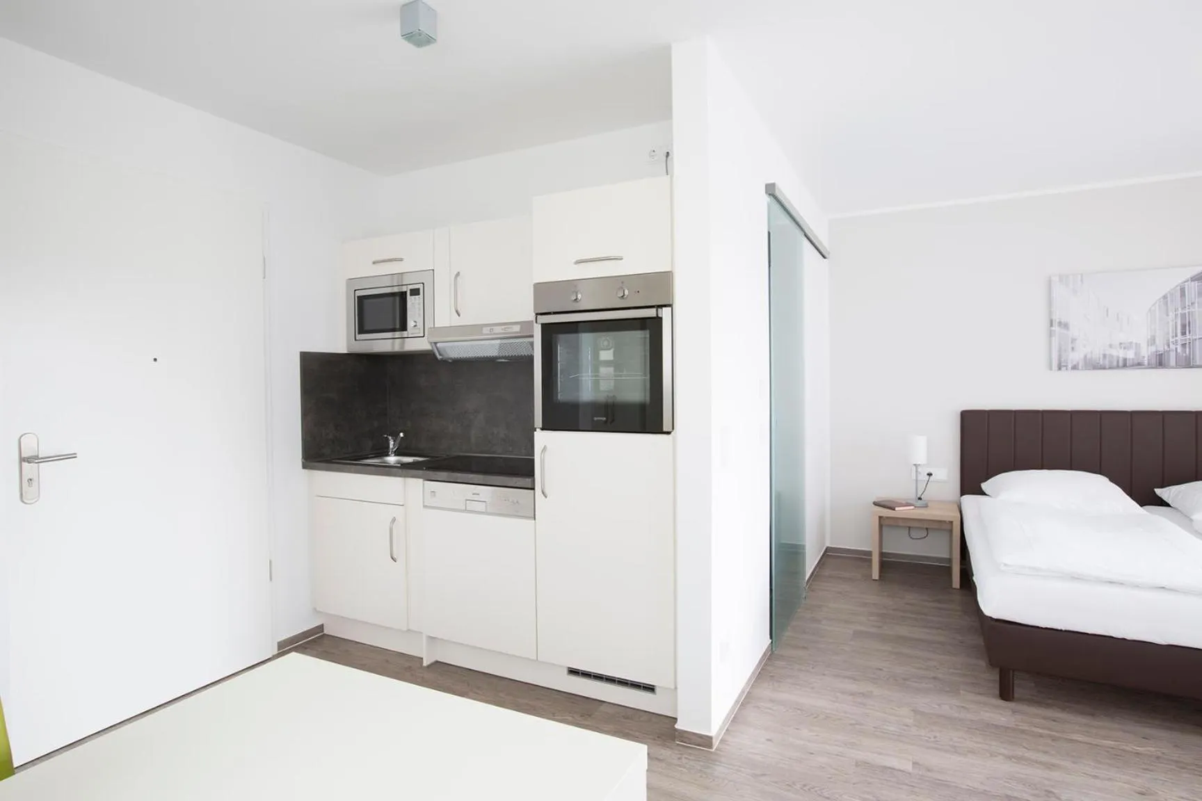 Kitchen or kitchenette, Bed in ADAPT APARTMENT HOTEL BERLIN - Adlershof