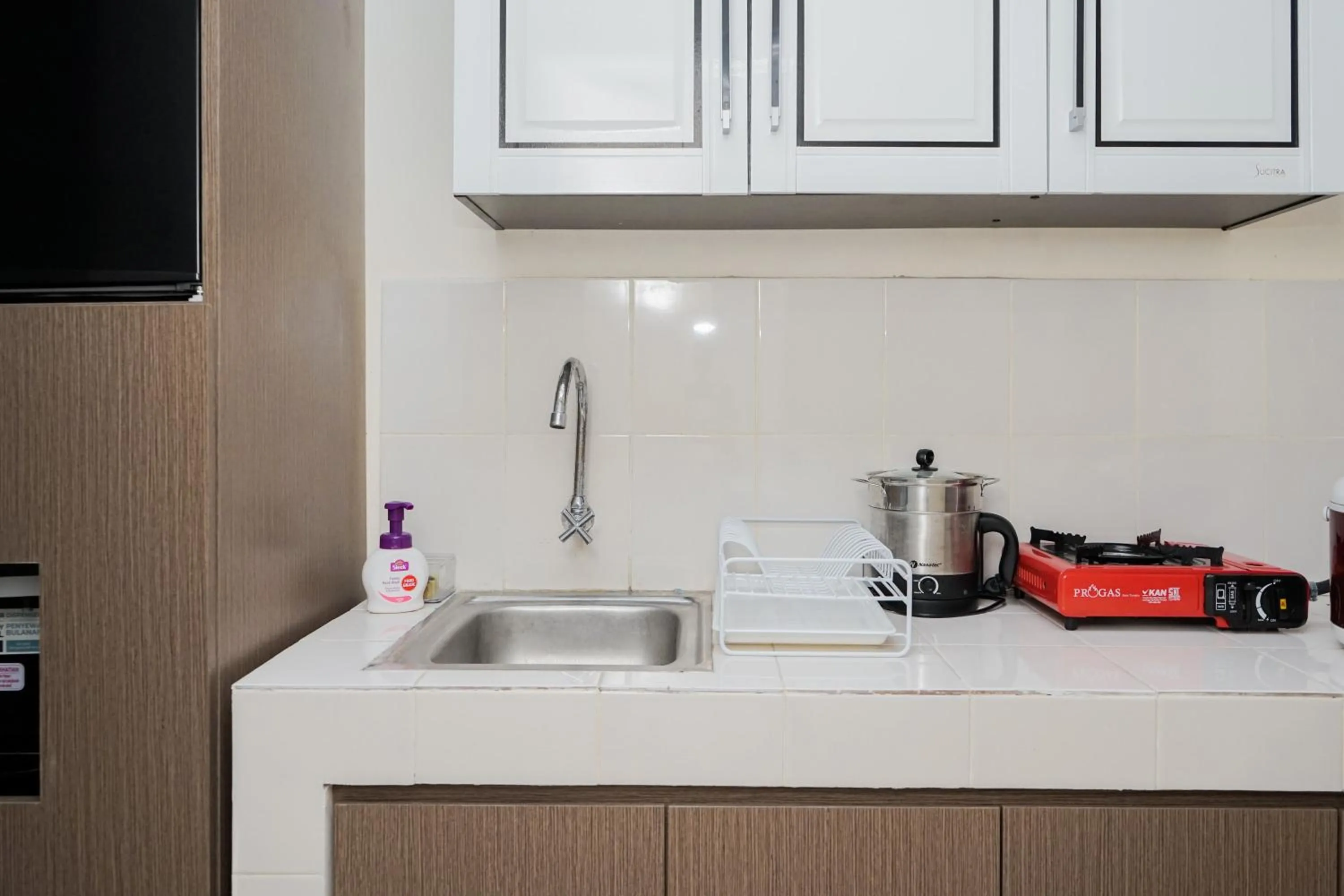 Kitchen or kitchenette in Homey and Comfact Studio at Medina Apartment By Travelio