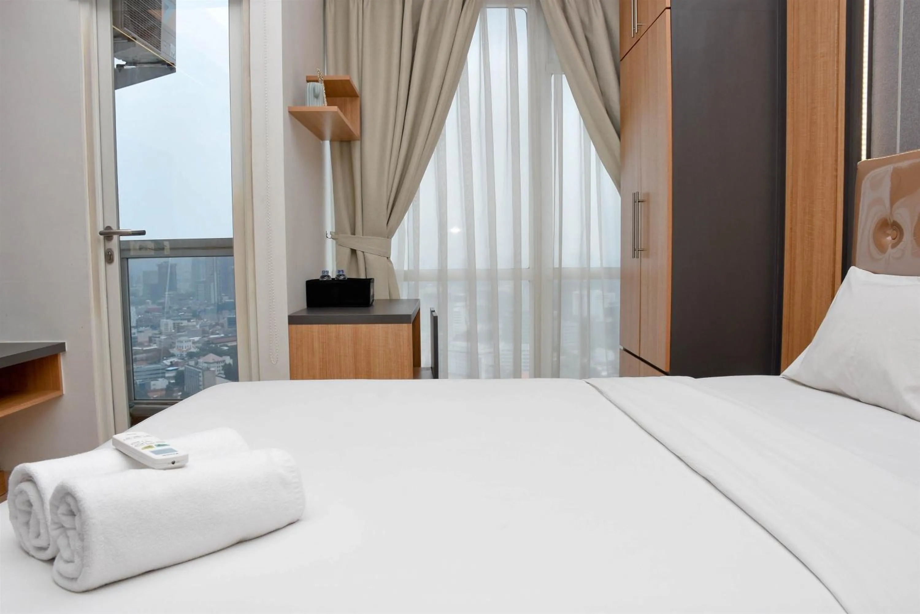 Bed in Cozy Living Studio at Menteng Park Apartment By Travelio