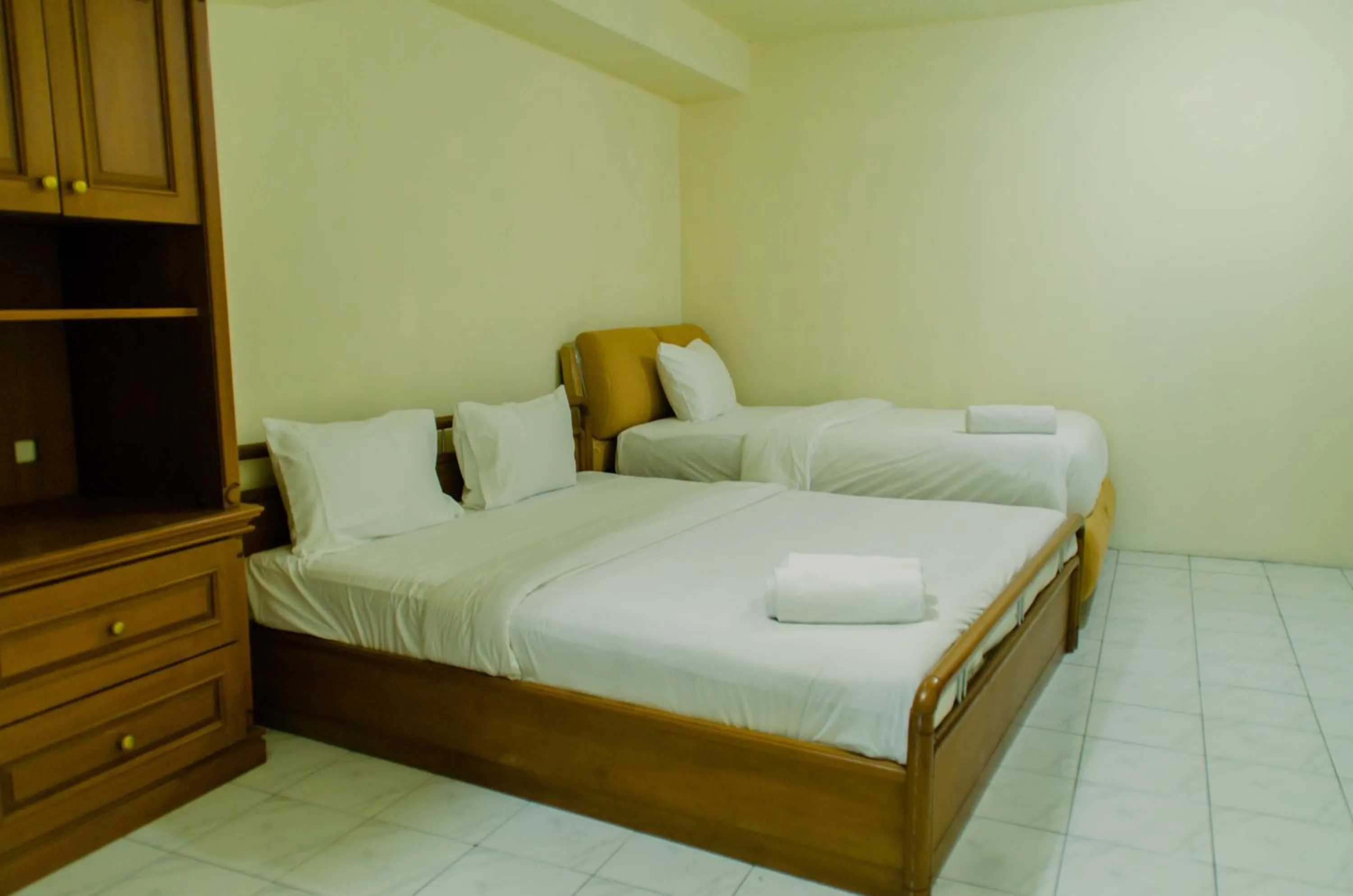 Bed in Spacious and Homey 3BR at Kondominium Rajawali Apartment By Travelio