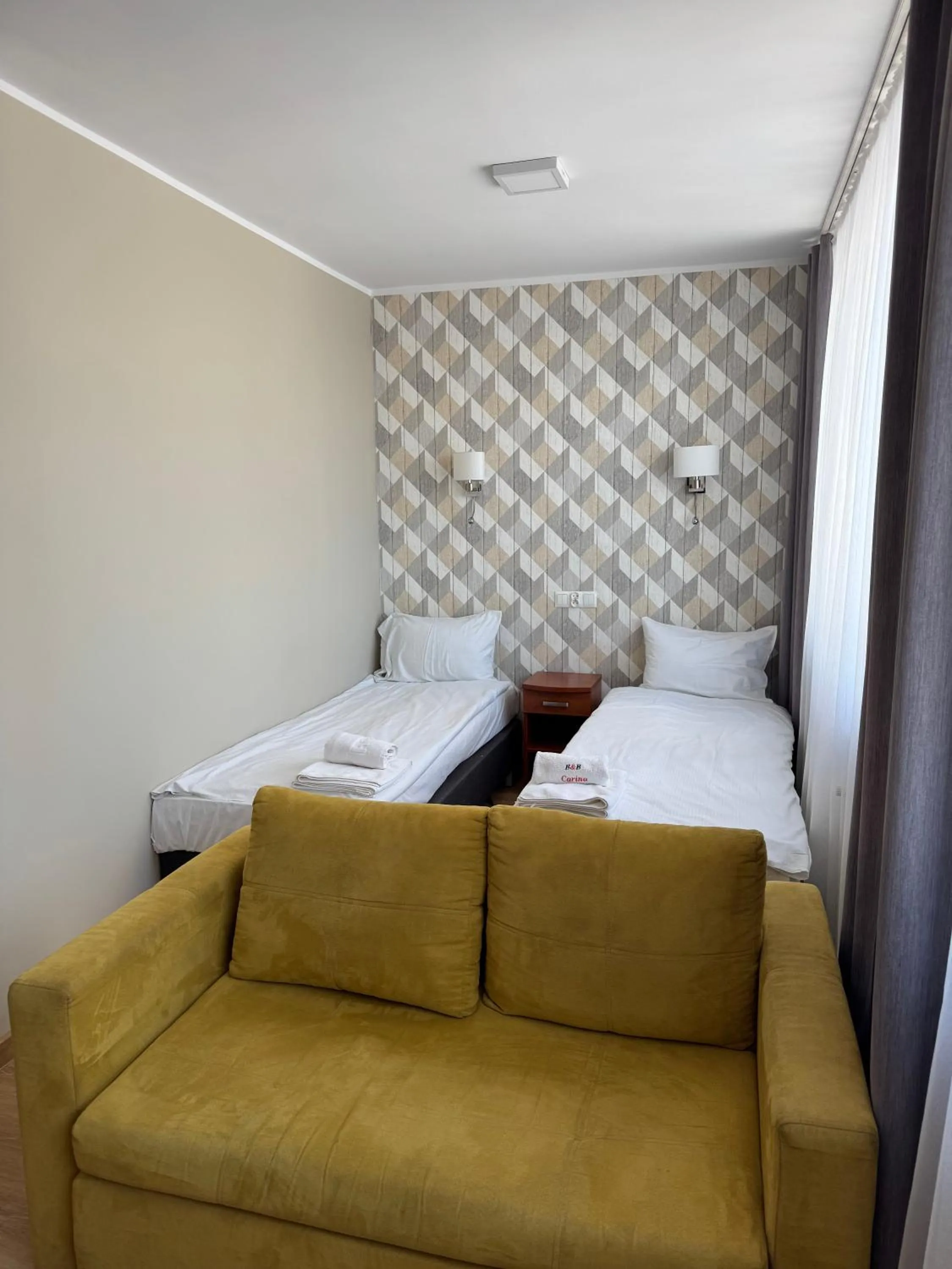 Seating area, Bed in Carina Hotel