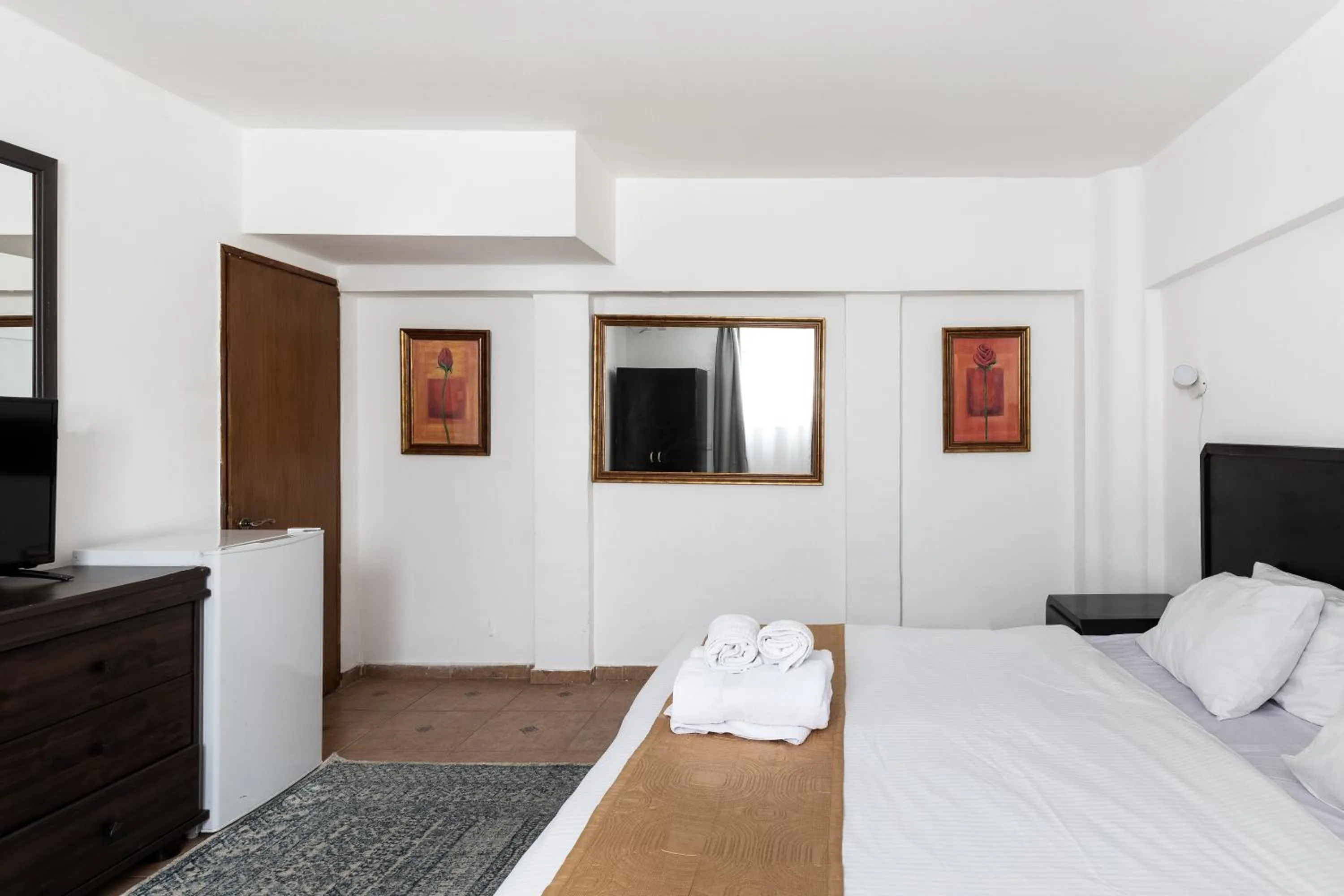 Bed, TV/Entertainment Center in The Colony Hotel