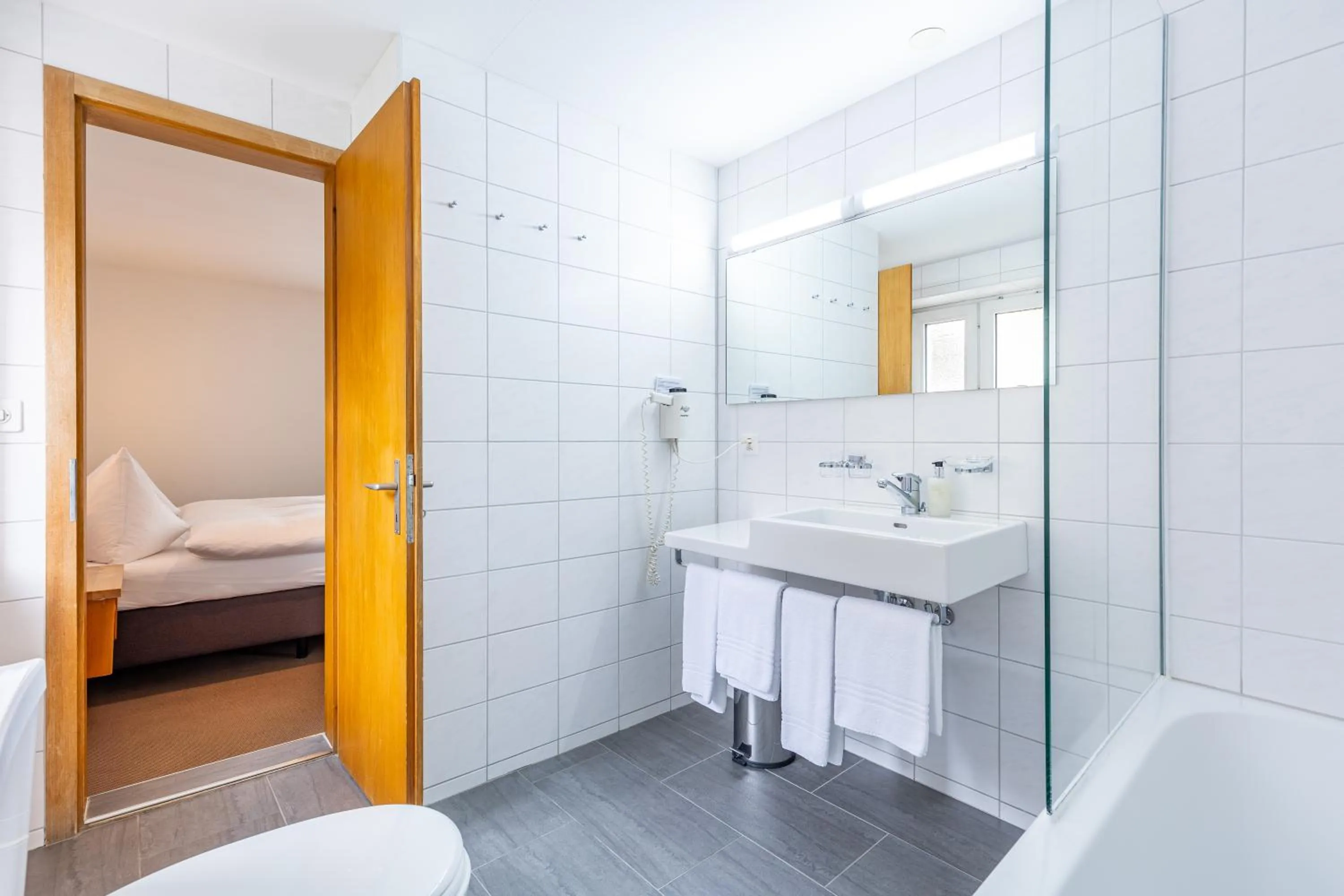 Bathroom, Bed in Hotel Dischma