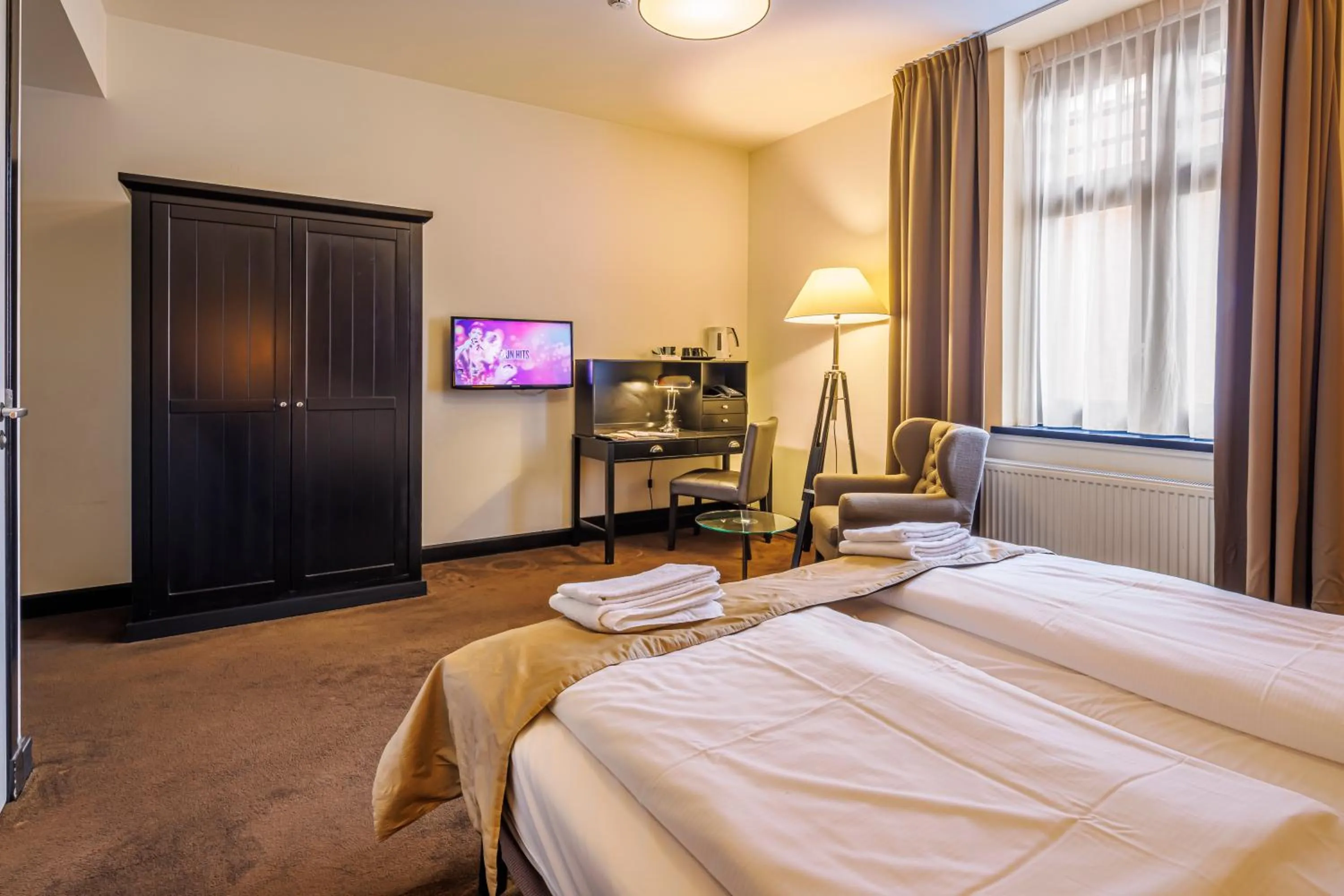 Communal lounge/ TV room, Bed in Grand Hotel Alkmaar