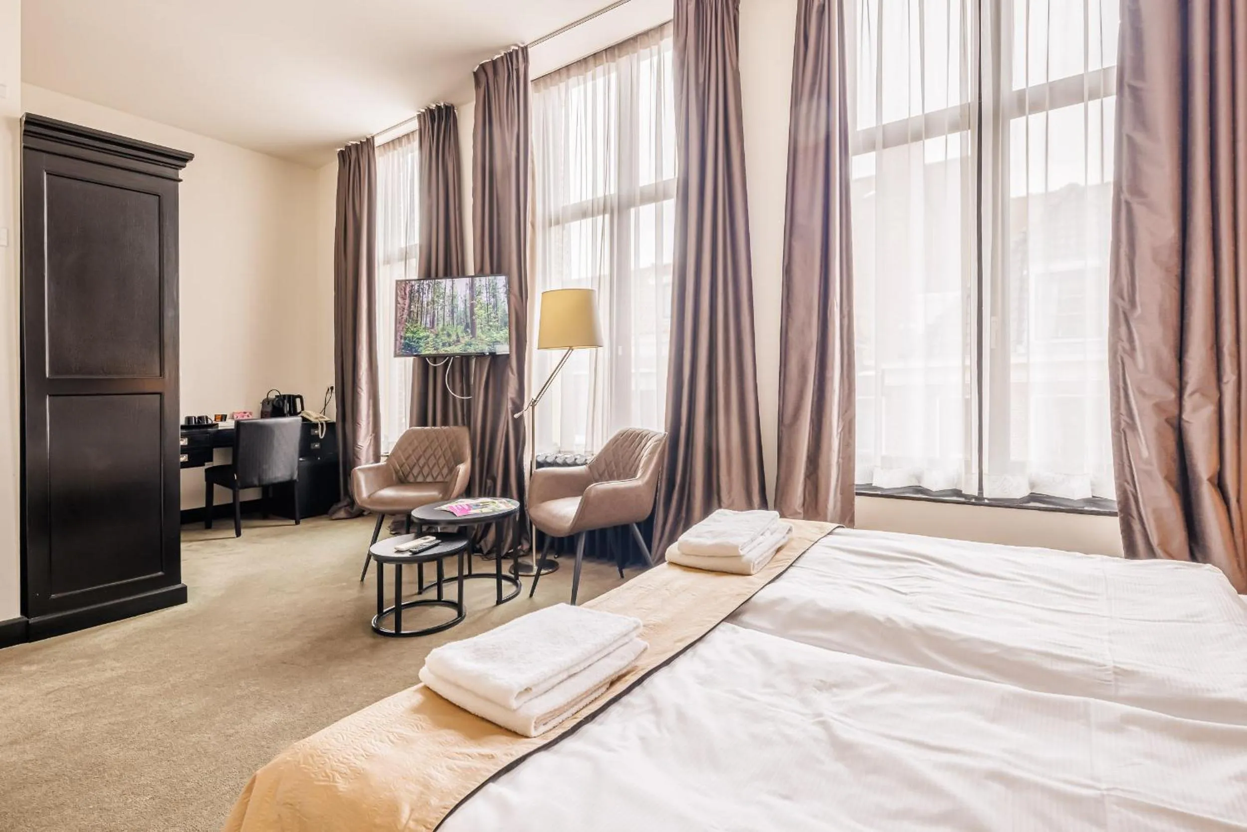 Communal lounge/ TV room, Bed in Grand Hotel Alkmaar