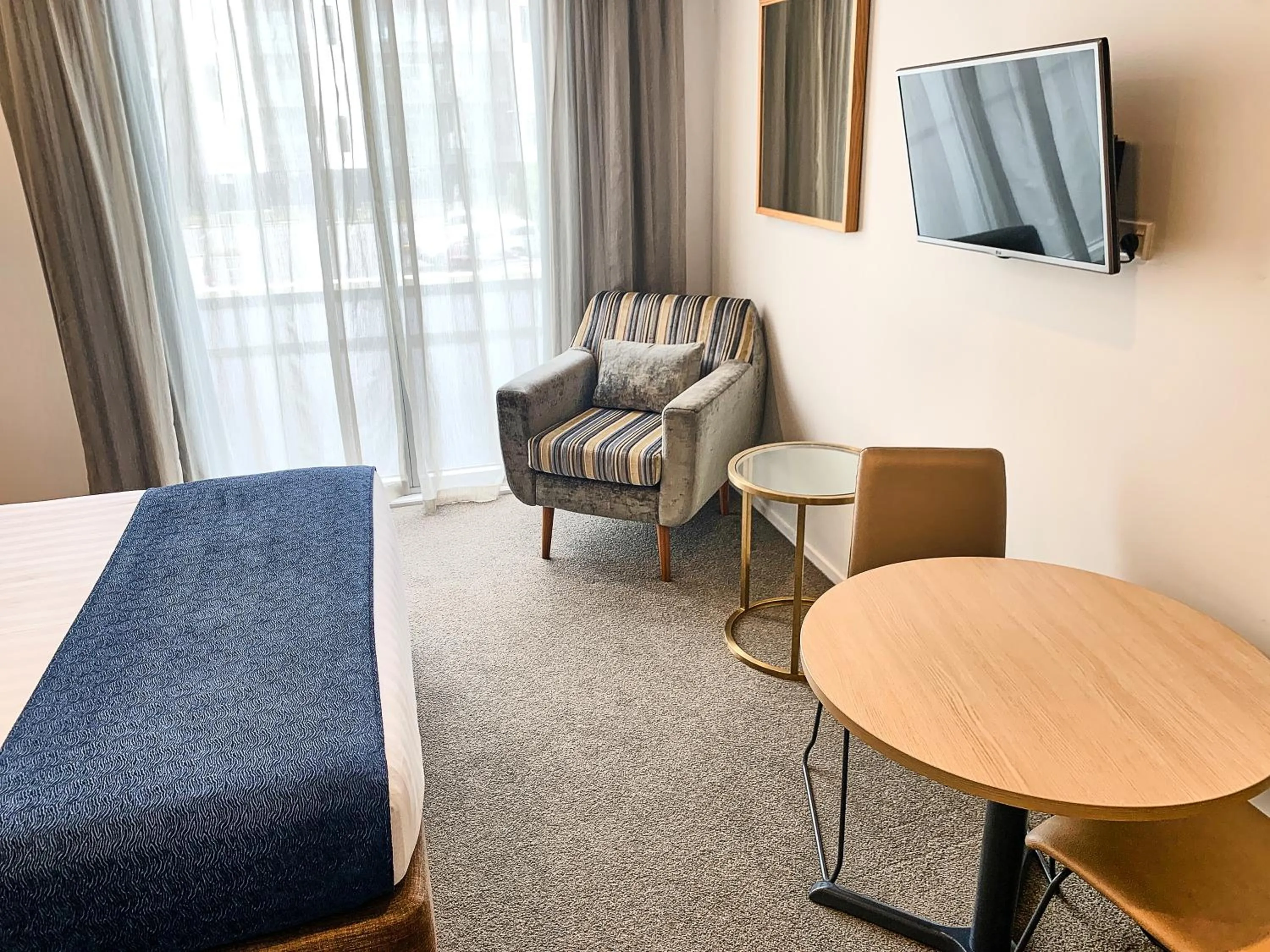 Living room, Bed in Ramada Suites by Wyndham Albany