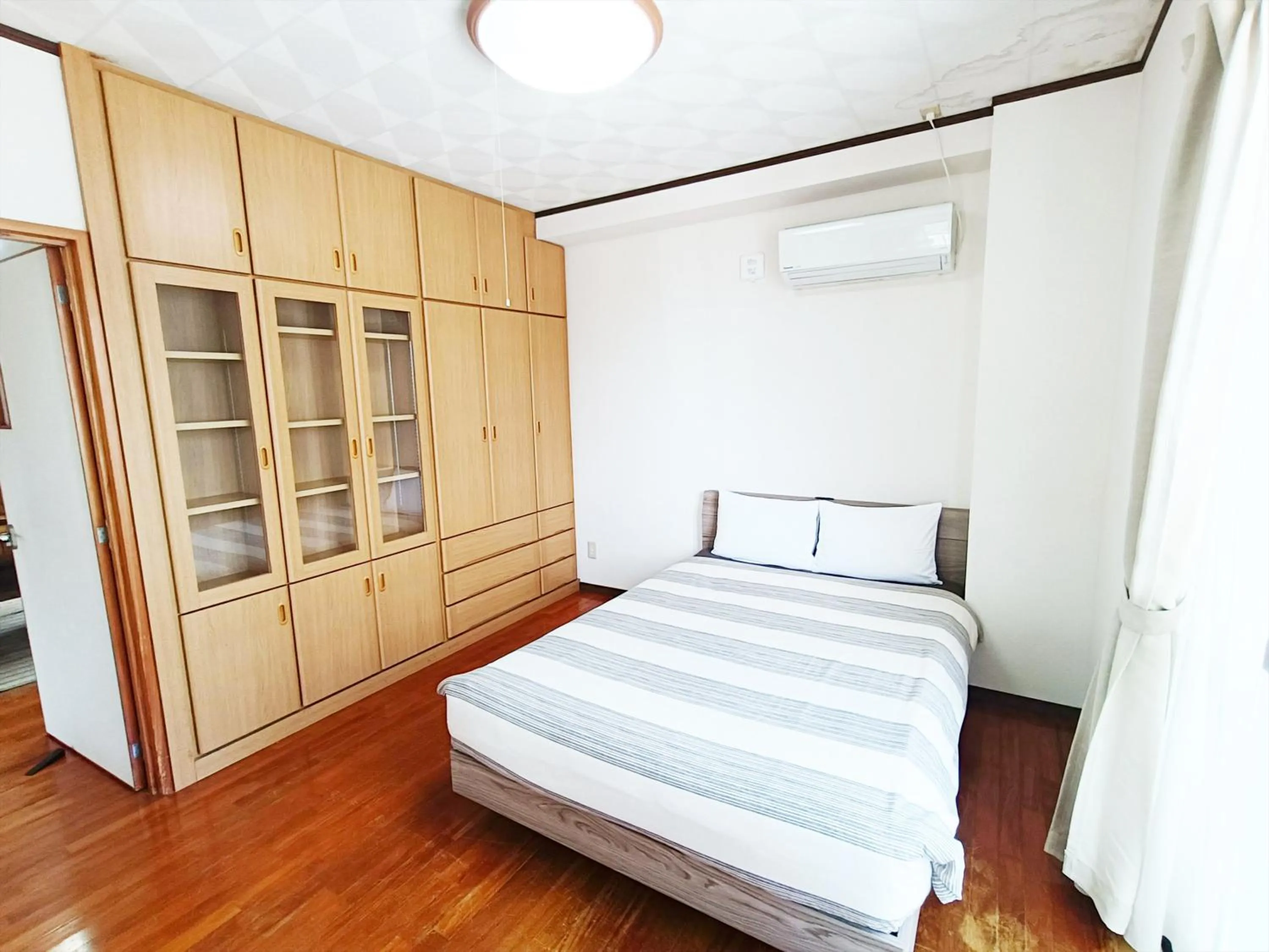 Bed in Kariyushi Condominium Resort Sea Side House