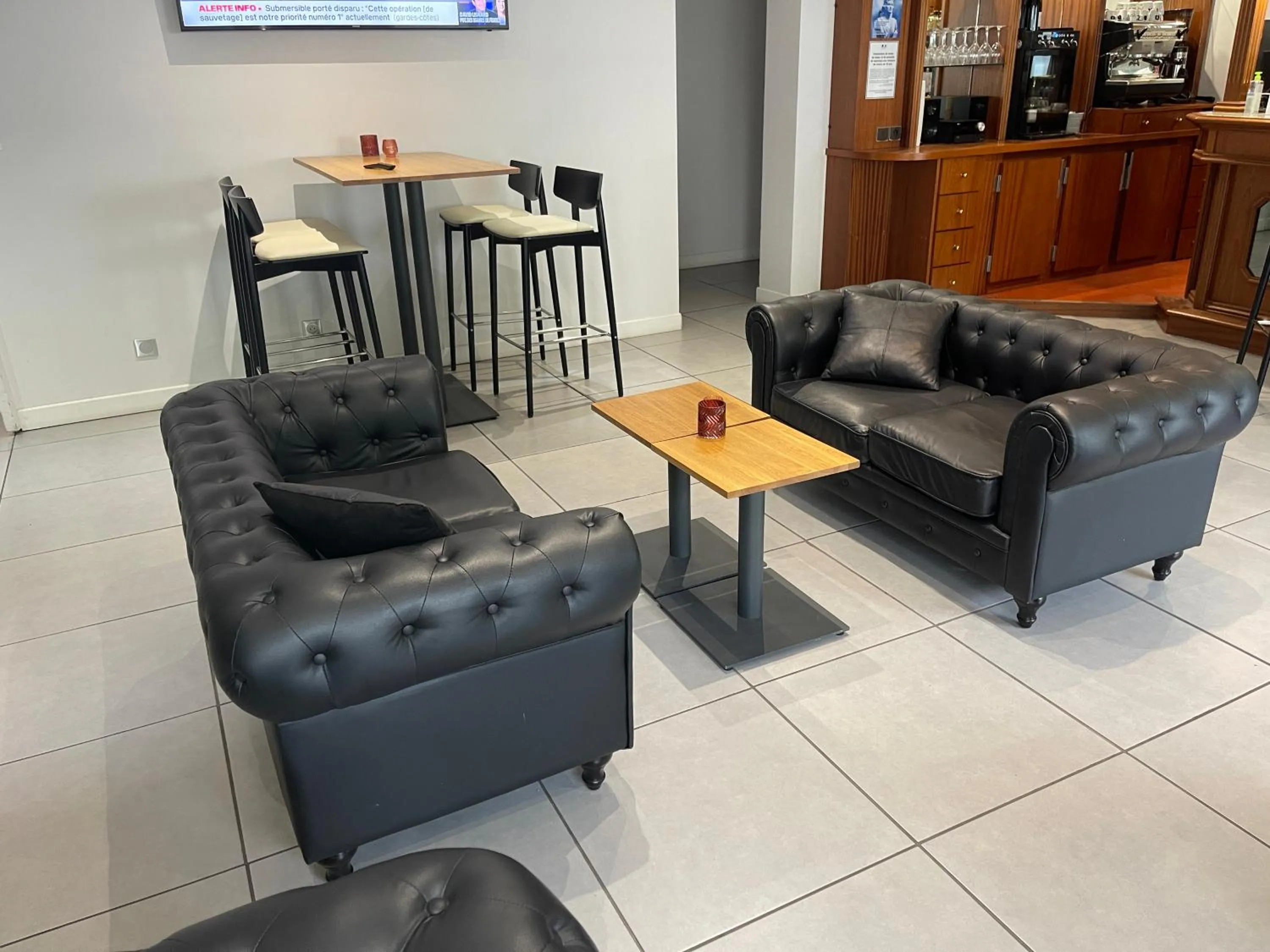 Communal lounge/ TV room in Cit'Hôtel le Welcome