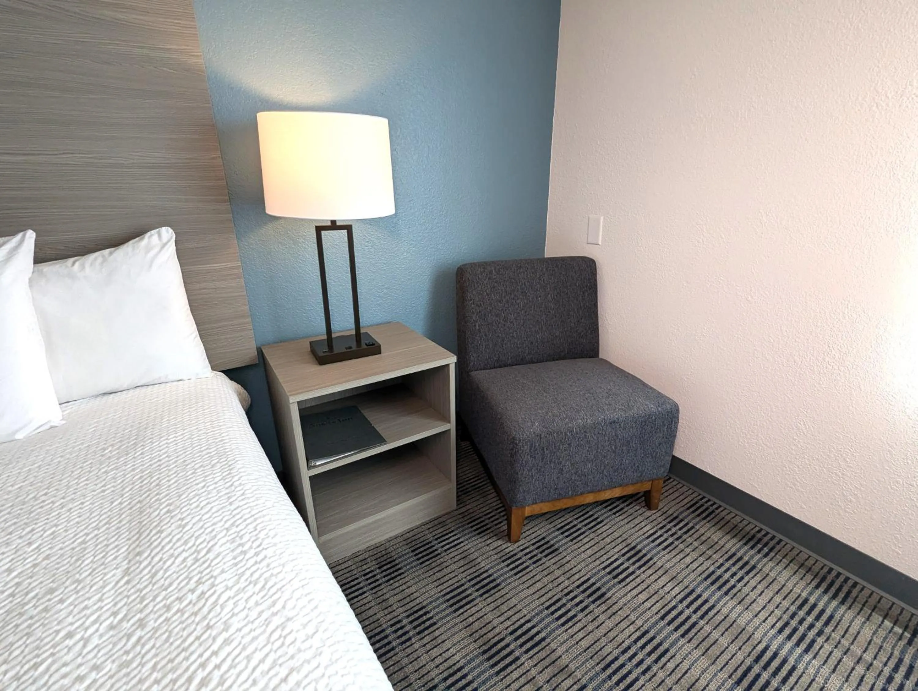 Seating area, Bed in AmericInn by Wyndham Baxter Brainerd