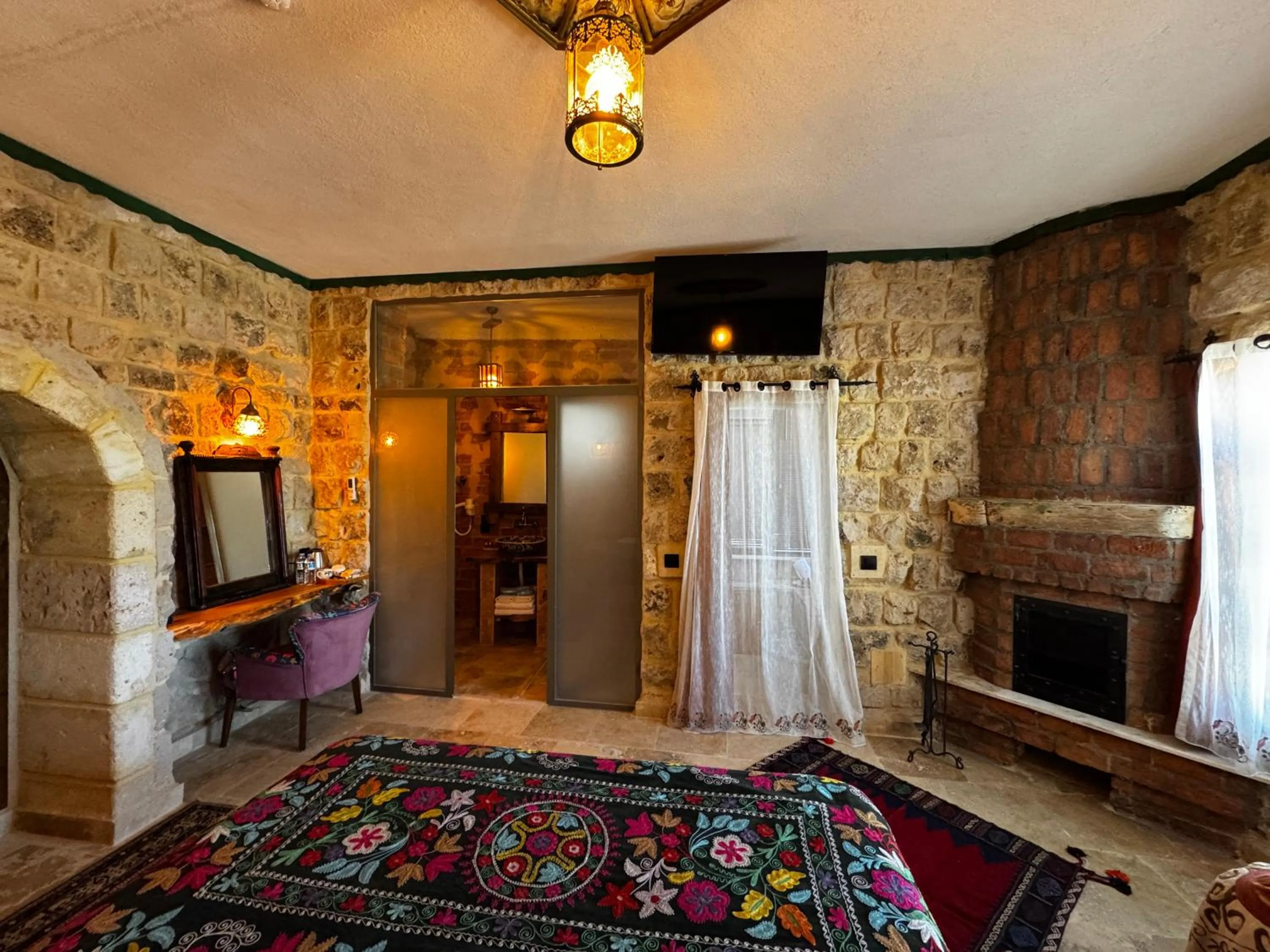 fireplace, Bed in Canela Cave Hotel - Cappadocia