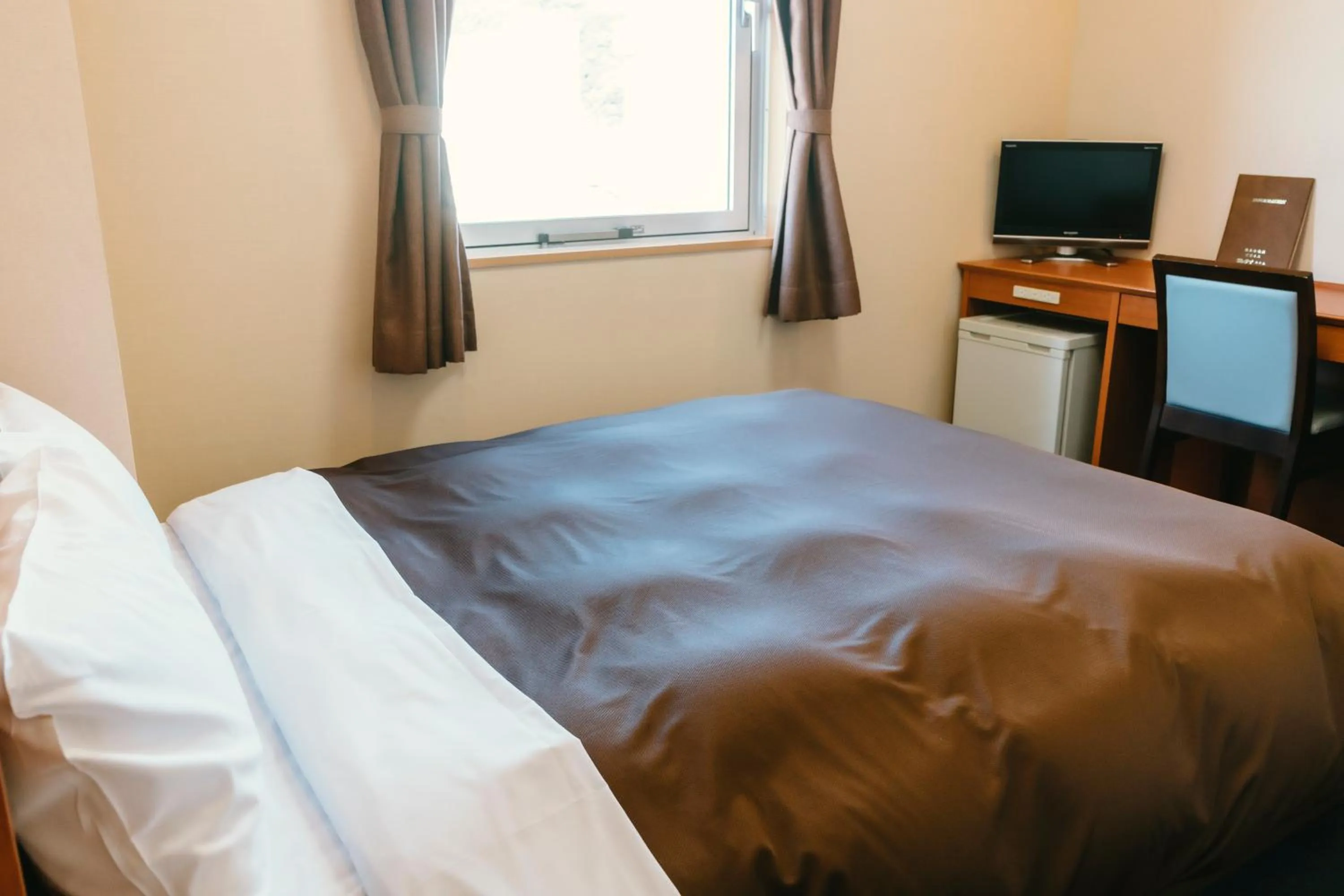 Bed in Kumamoto Ichibamae Business Kurenai Hotel