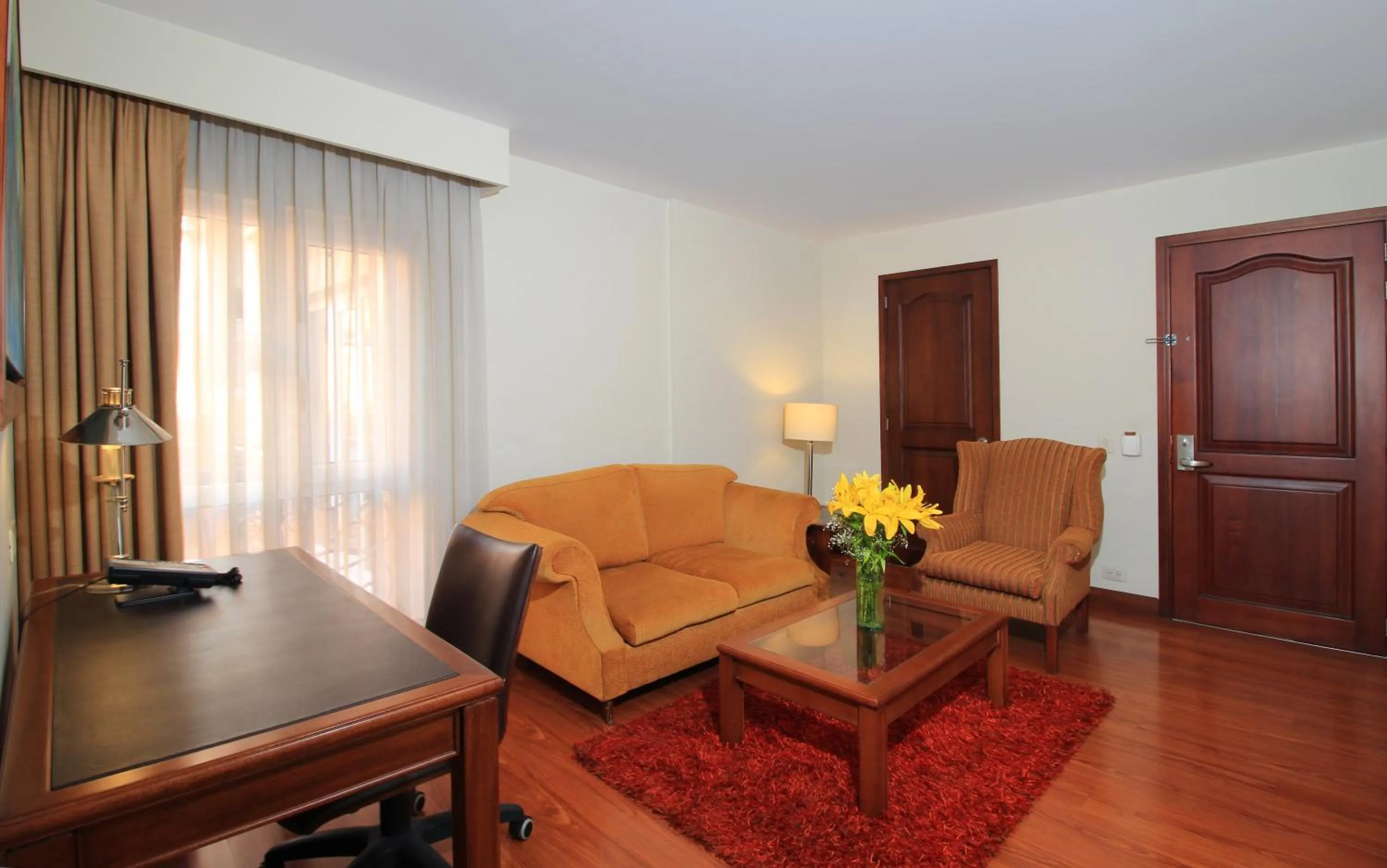 Communal lounge/ TV room in Hotel Windsor House Inn By GEH Suites