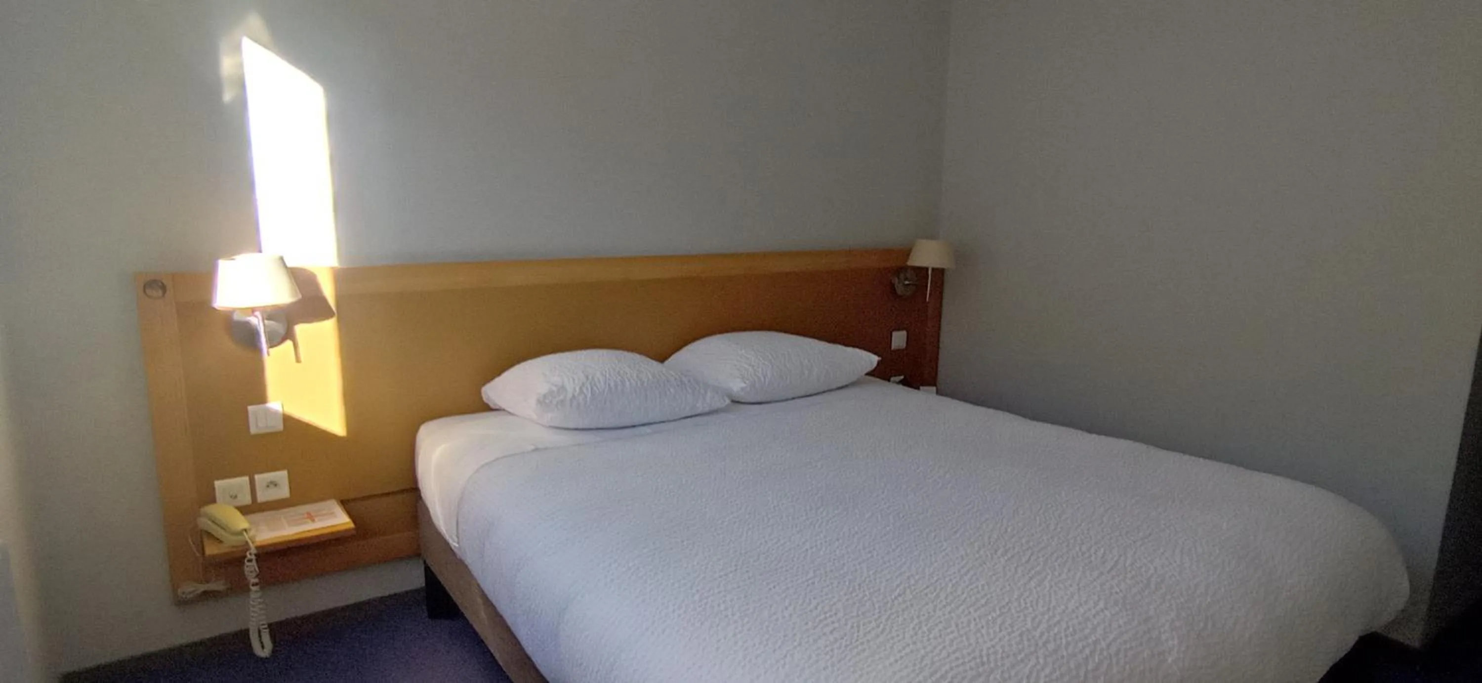 Bed in Logis Hotel Restaurant Le Cygne