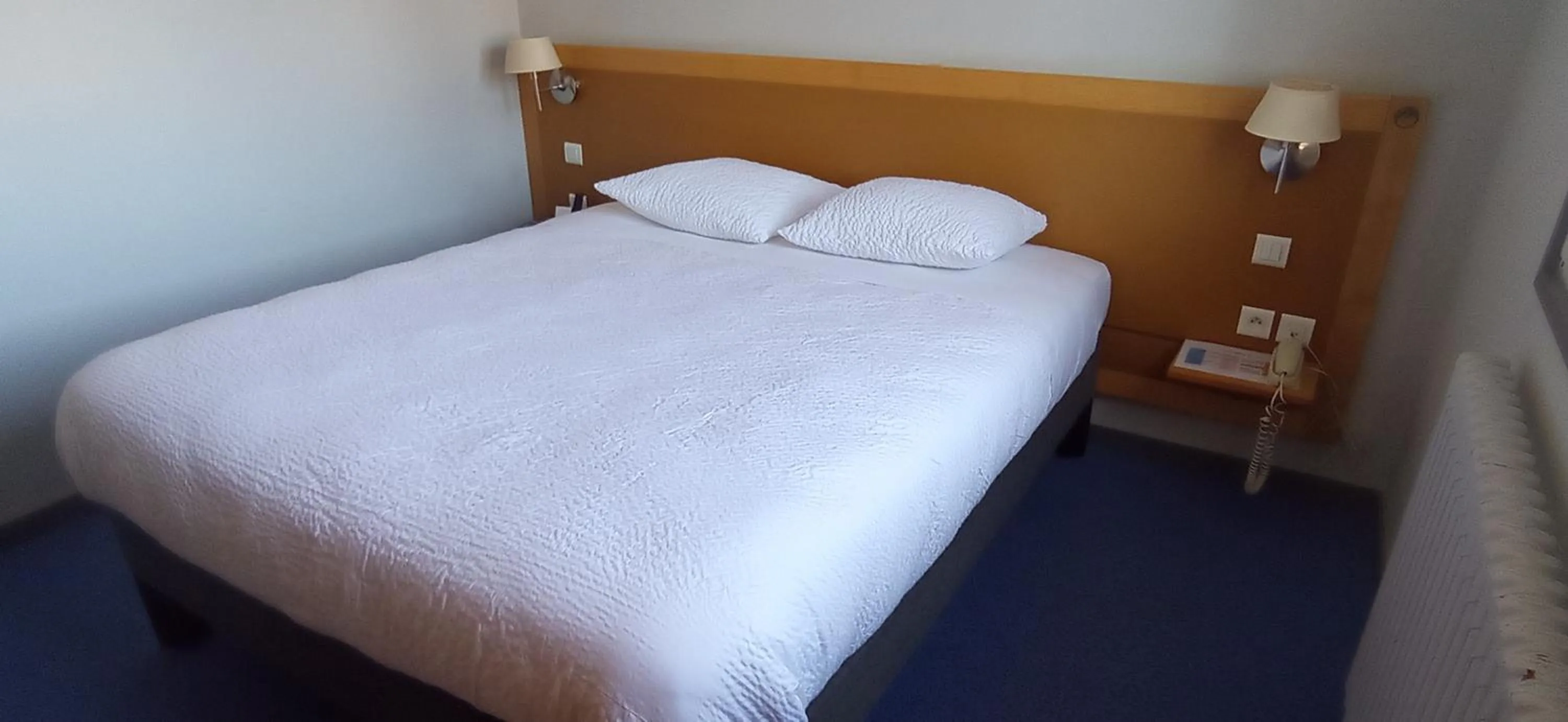 Bed in Logis Hotel Restaurant Le Cygne