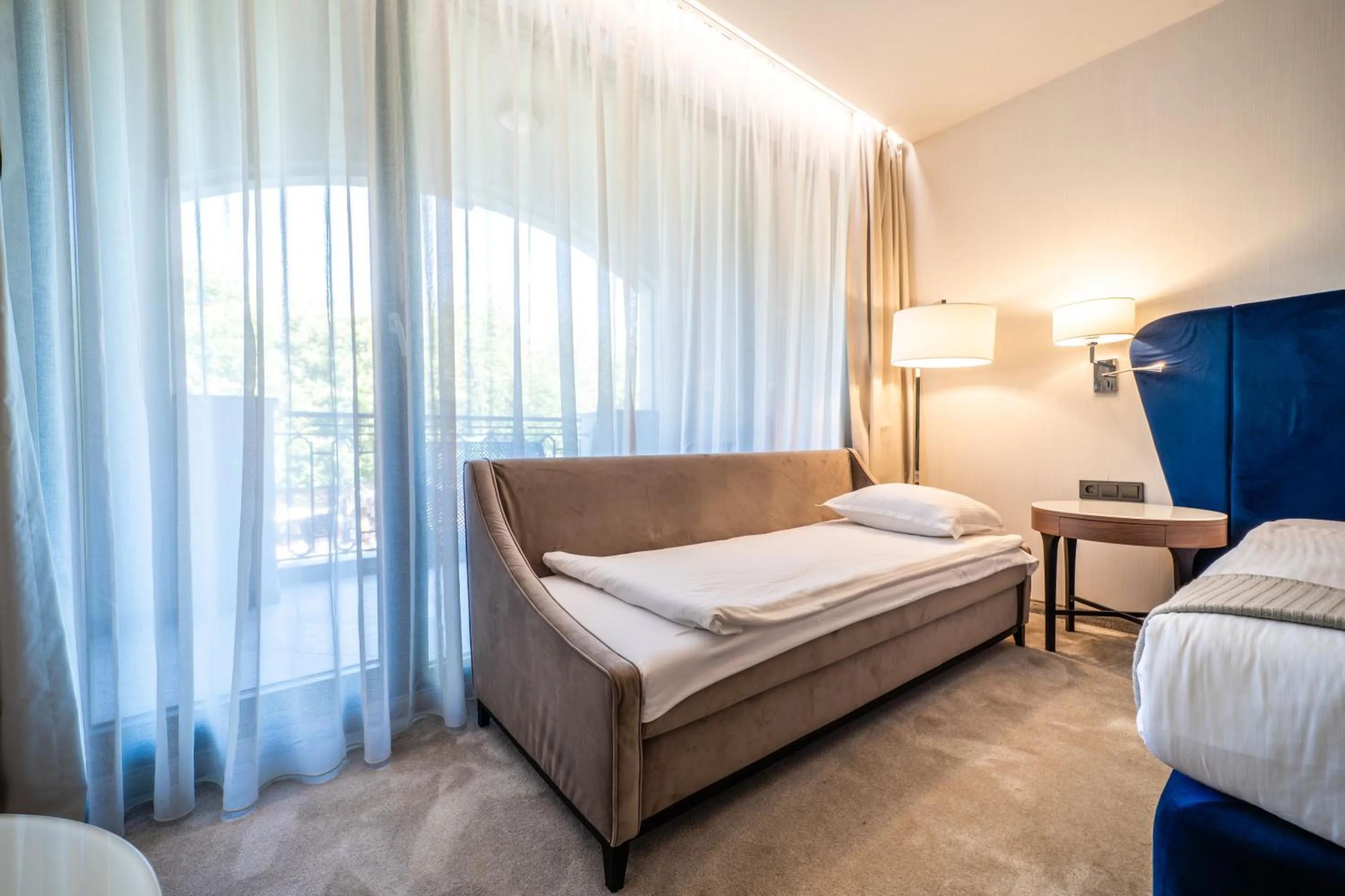 Bed in Astor Garden Hotel