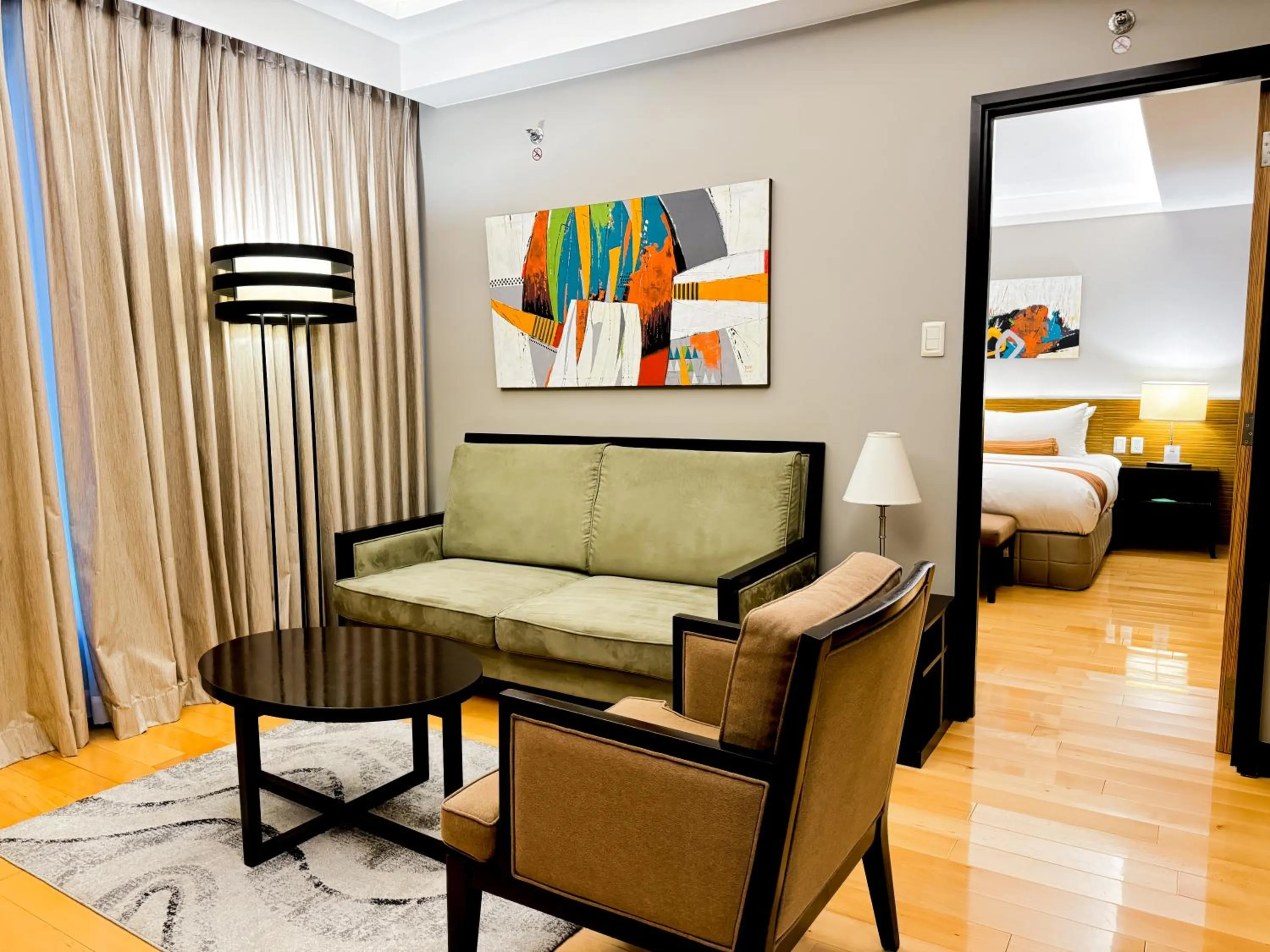 Living room, Bed in The Bellevue Manila