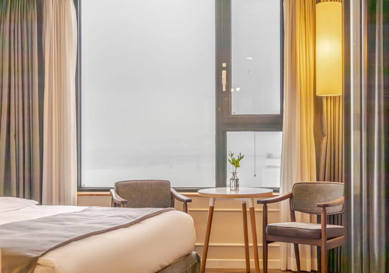 Seating area, Bed in JK Blossom Hotel