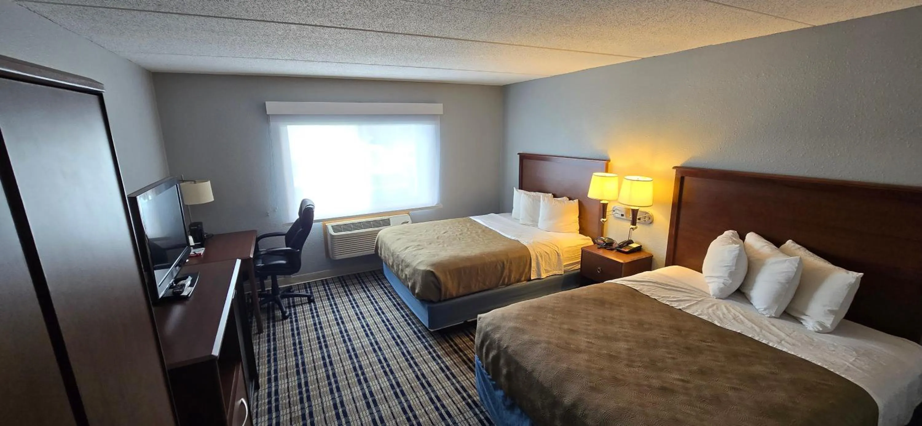 Bed in AmericInn by Wyndham Austin