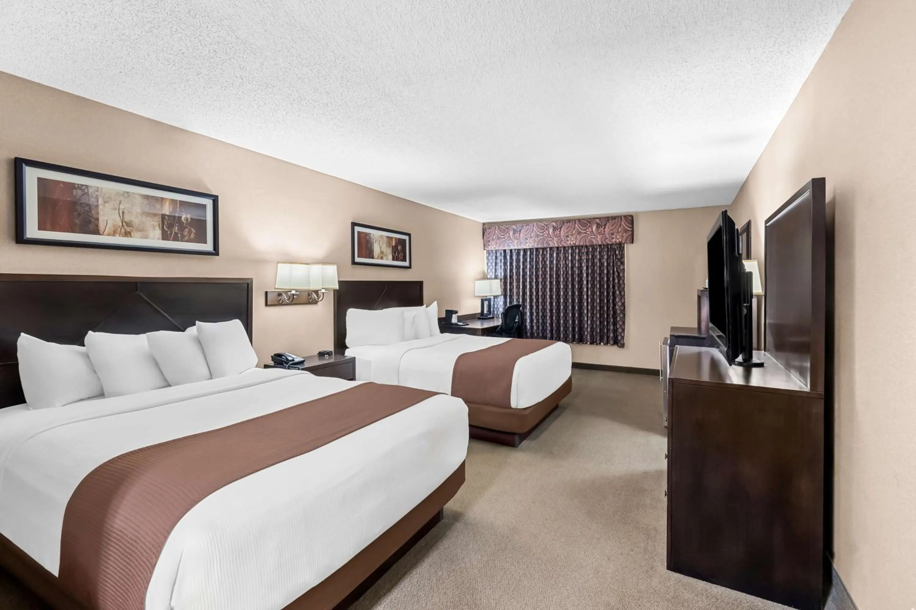 Bedroom, Bed in Heartland Inn & Suites, SureStay Collection by Best Western