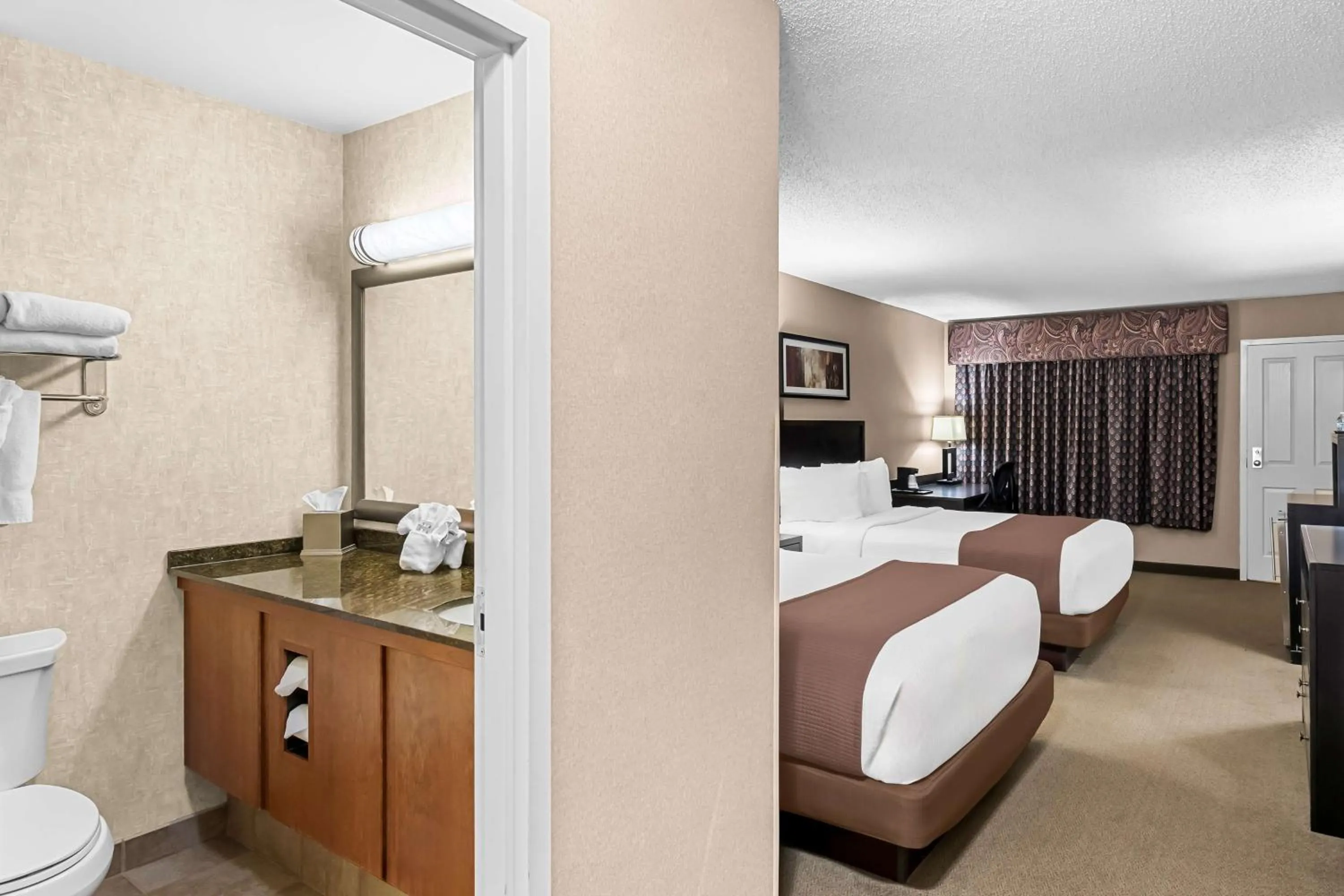Bedroom, Bed in Heartland Inn & Suites, SureStay Collection by Best Western