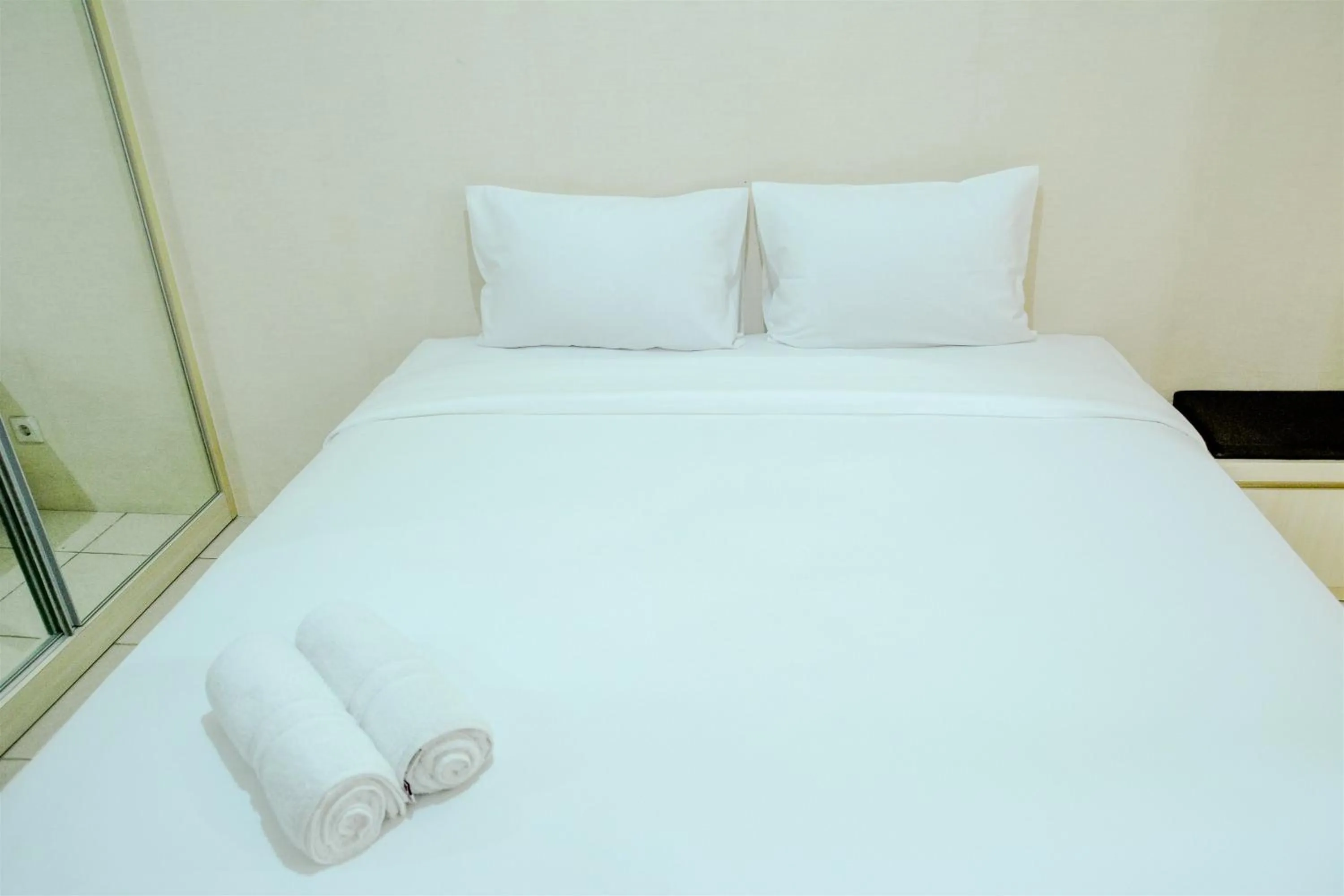Bed in Minimalist Studio Room at Grand Serpong Apartment By Travelio