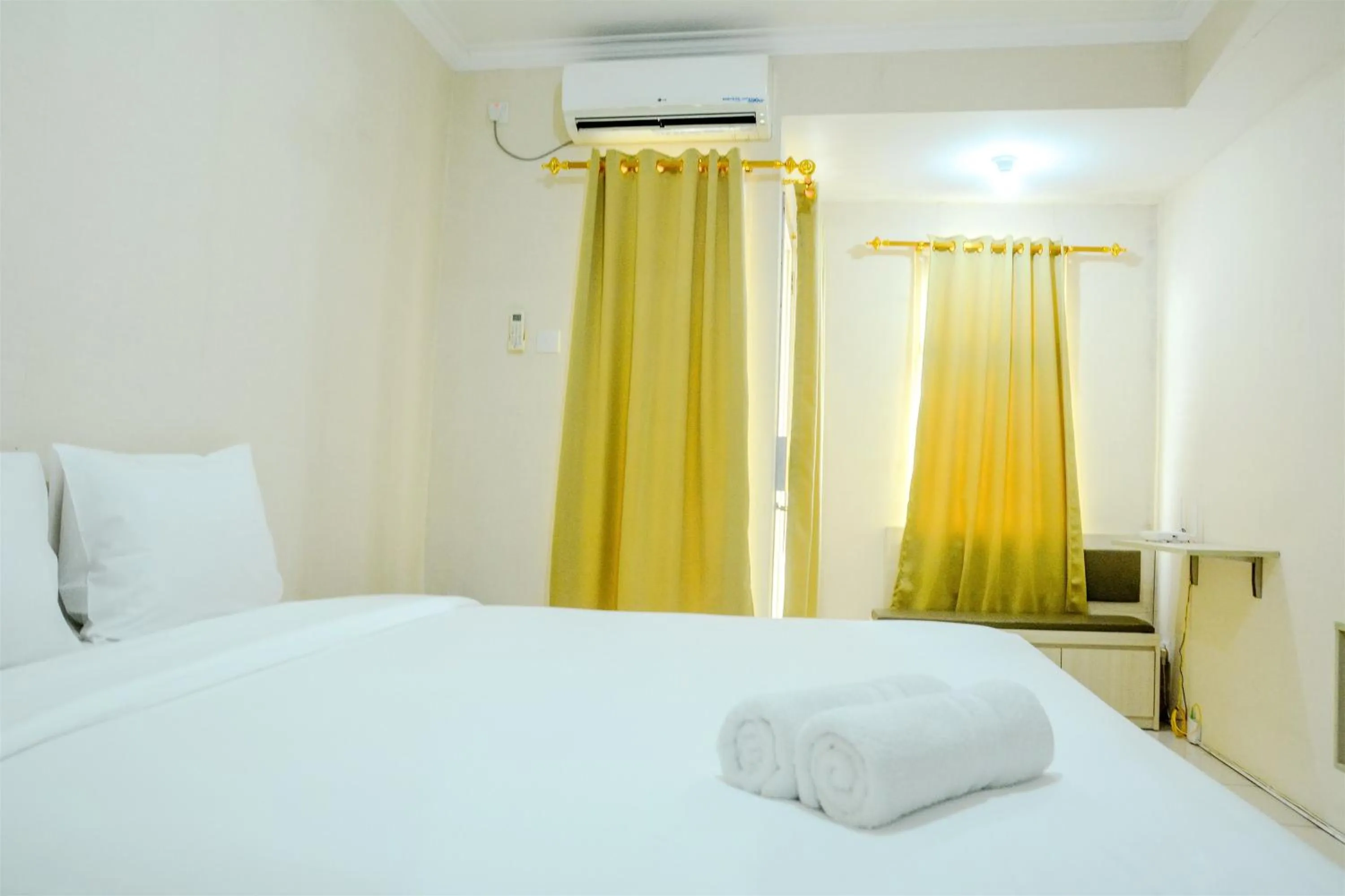 Bed in Minimalist Studio Room at Grand Serpong Apartment By Travelio