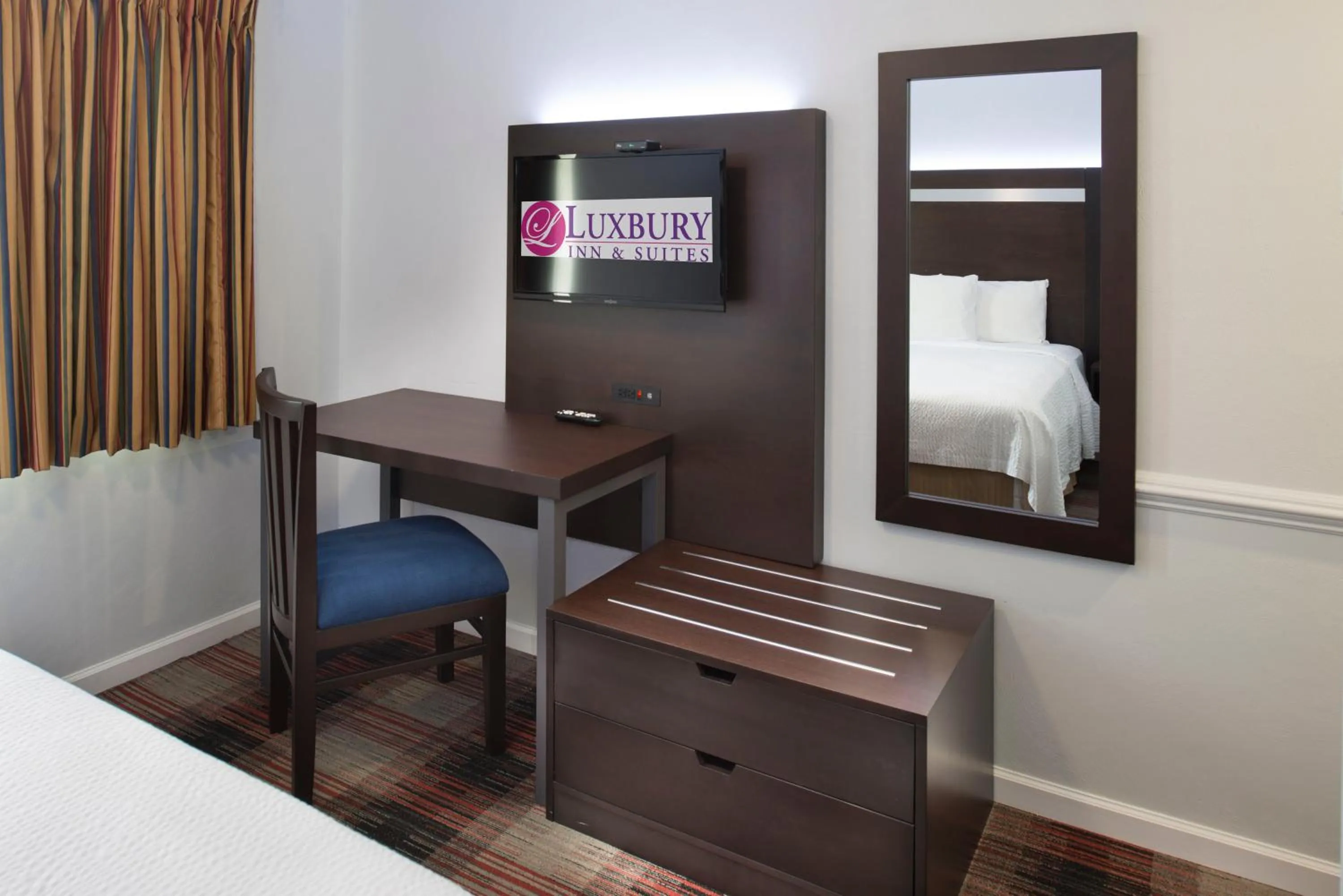 Bed in Luxbury Inn & Suites