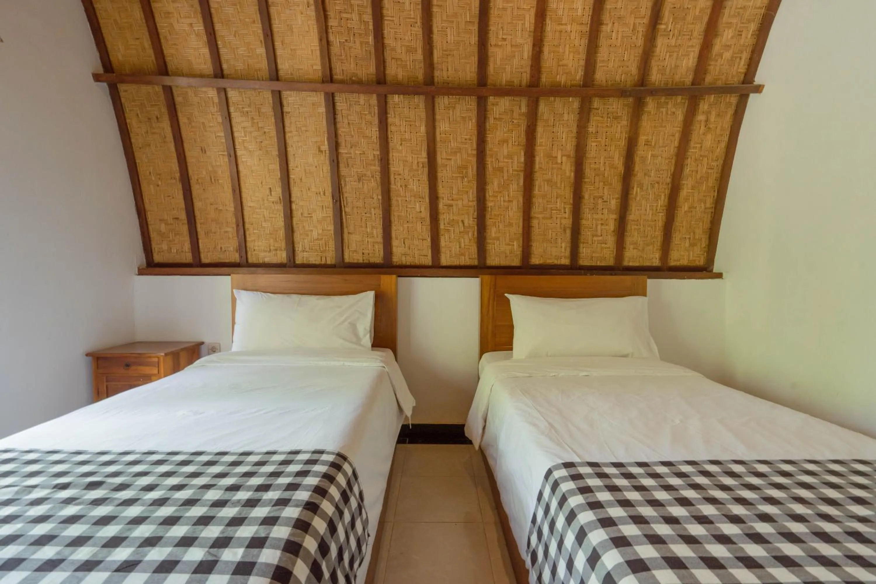Bed in Ratu Cottage by OurStory Travels