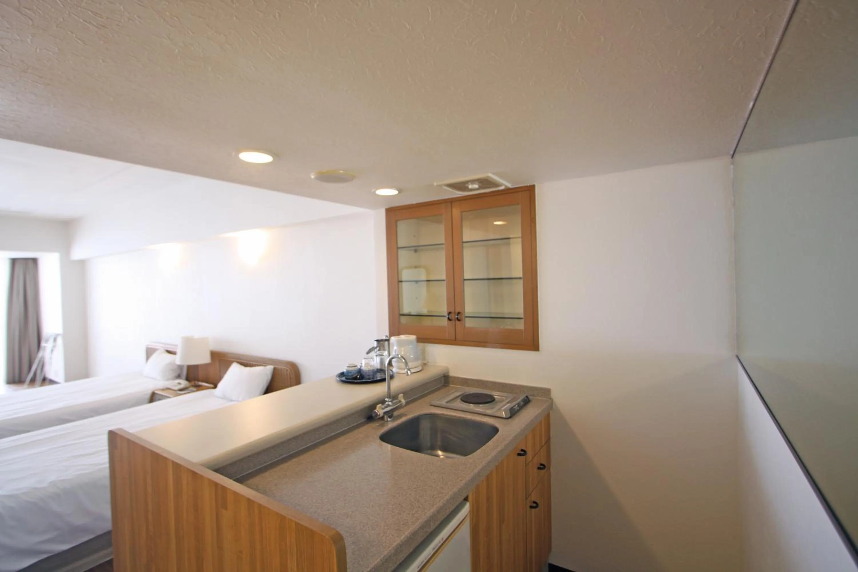 Kitchen or kitchenette, Bed in Hotel Mahaina Wellness Resorts Okinawa