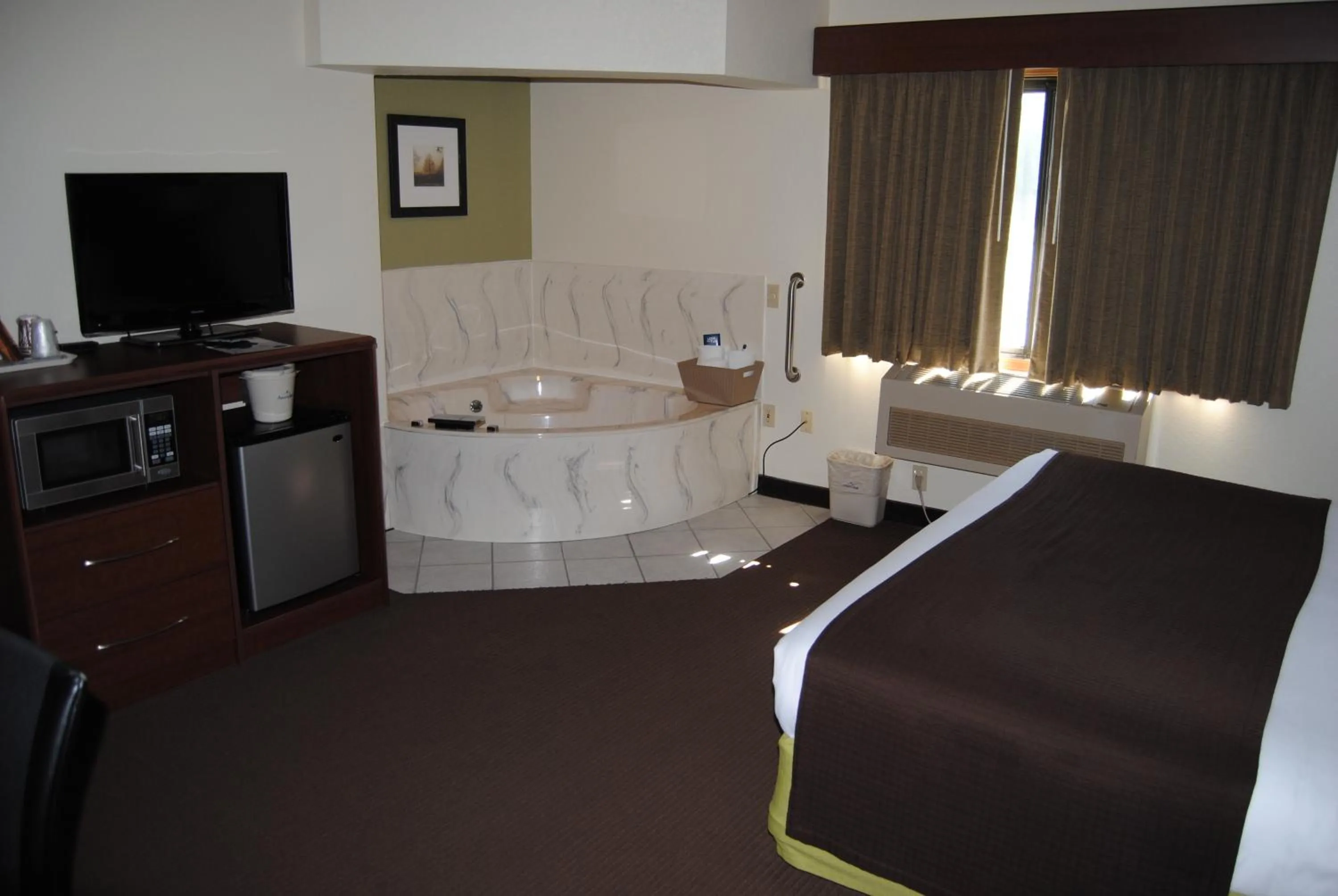 Bed in AmericInn by Wyndham Grand Rapids