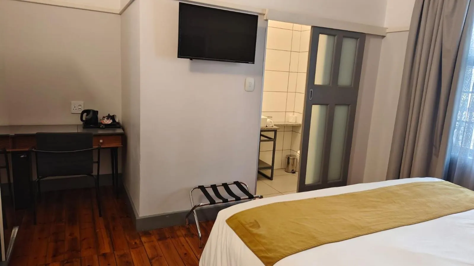 Communal lounge/ TV room, Bed in THE Pretoria Hotel