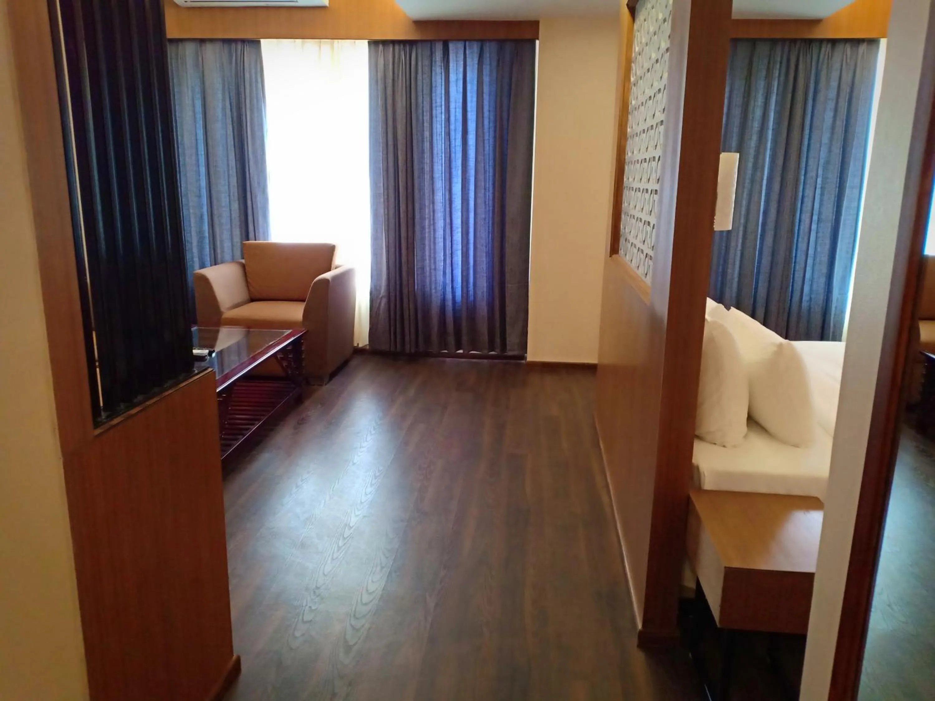 Seating area, Bed in Pipul Padmaja Premium Hotel