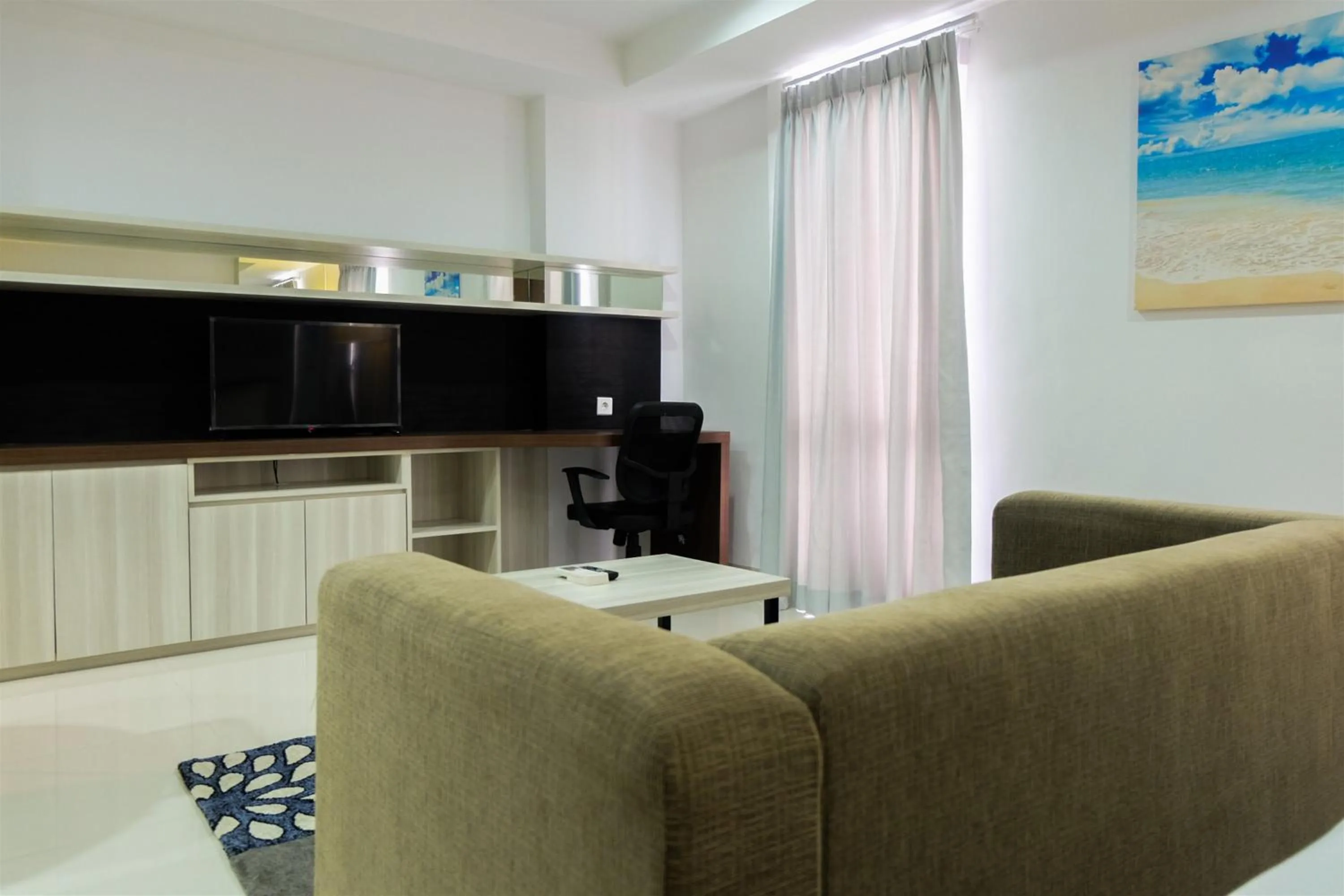 Seating area in Studio Room Azalea Suites Apartment By Travelio