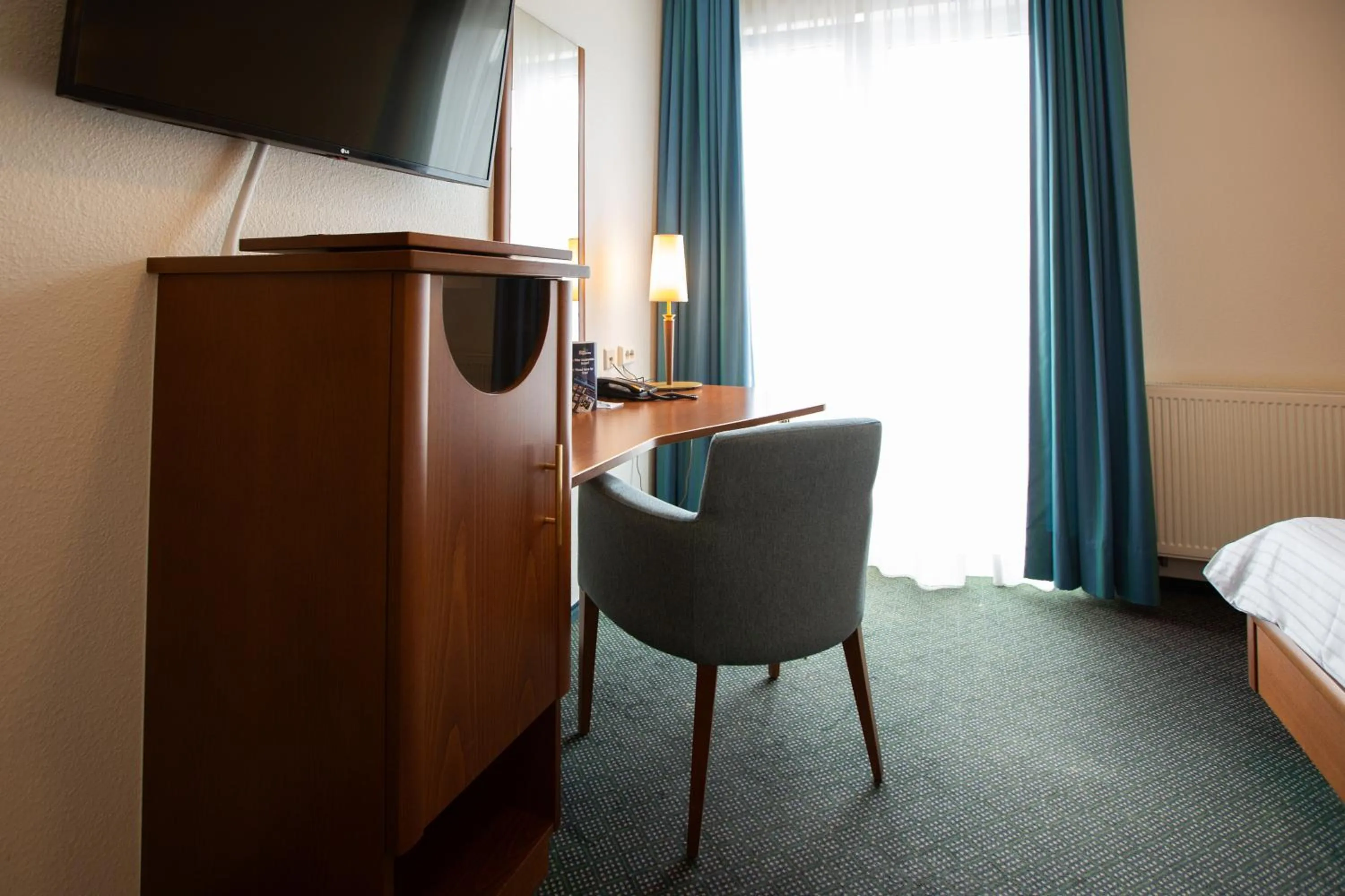 Communal lounge/ TV room, Bed in Ringhotel Appelbaum Gütersloh