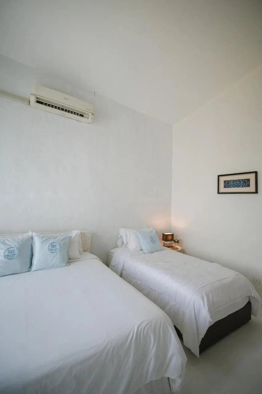 Bed in White Wall Riverfront Hotel