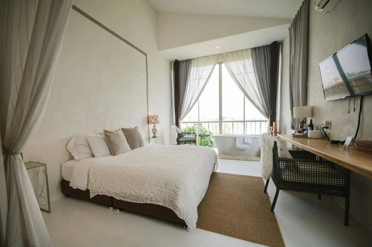 Bed in White Wall Riverfront Hotel