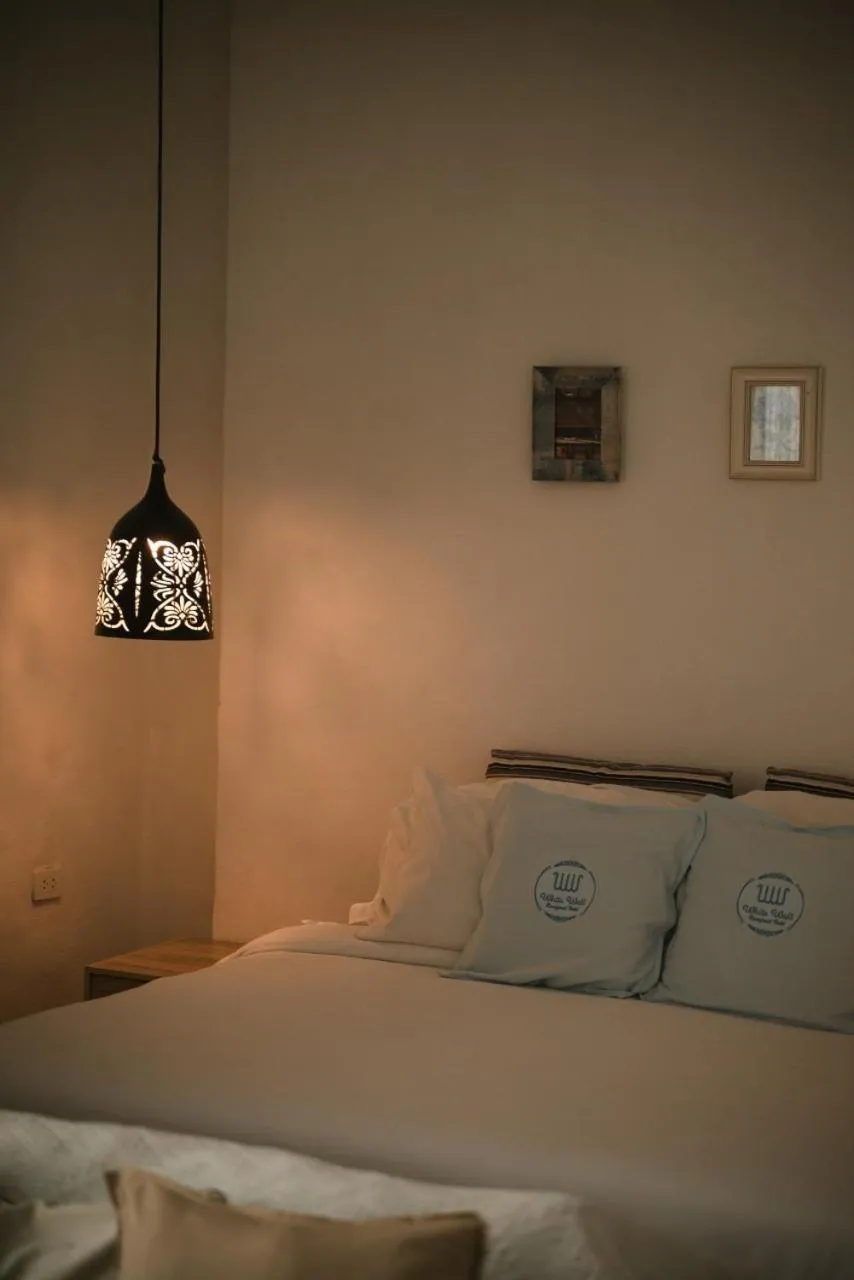 Bed in White Wall Riverfront Hotel